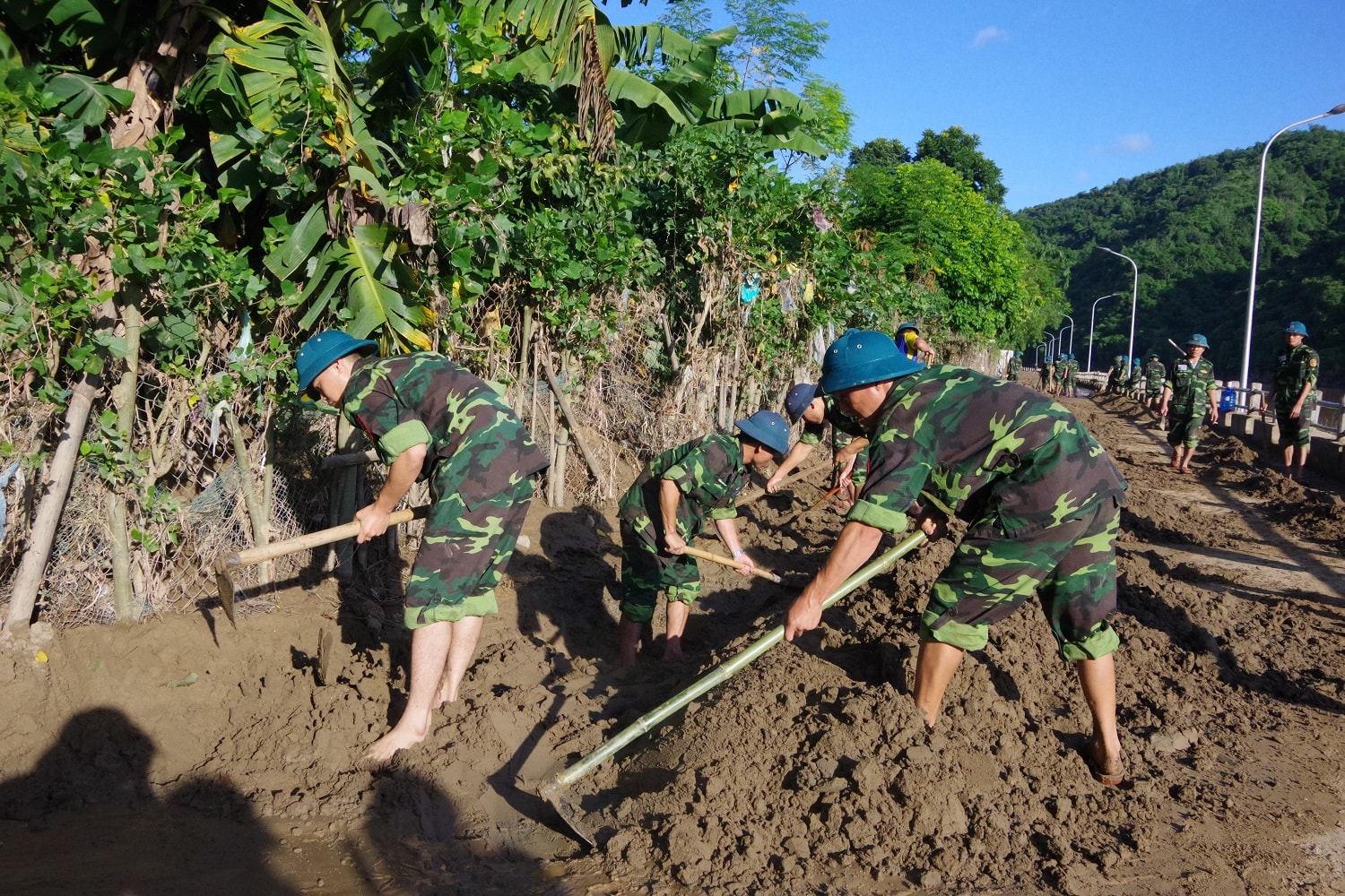 Cán bộ, học viên Trường Quân sự tỉnh nạo vét bùn đất tại tuyến đê ven sông Lam tại thị trấn Hòa Bình, huyện Tương Dương ảnh Phong Quang