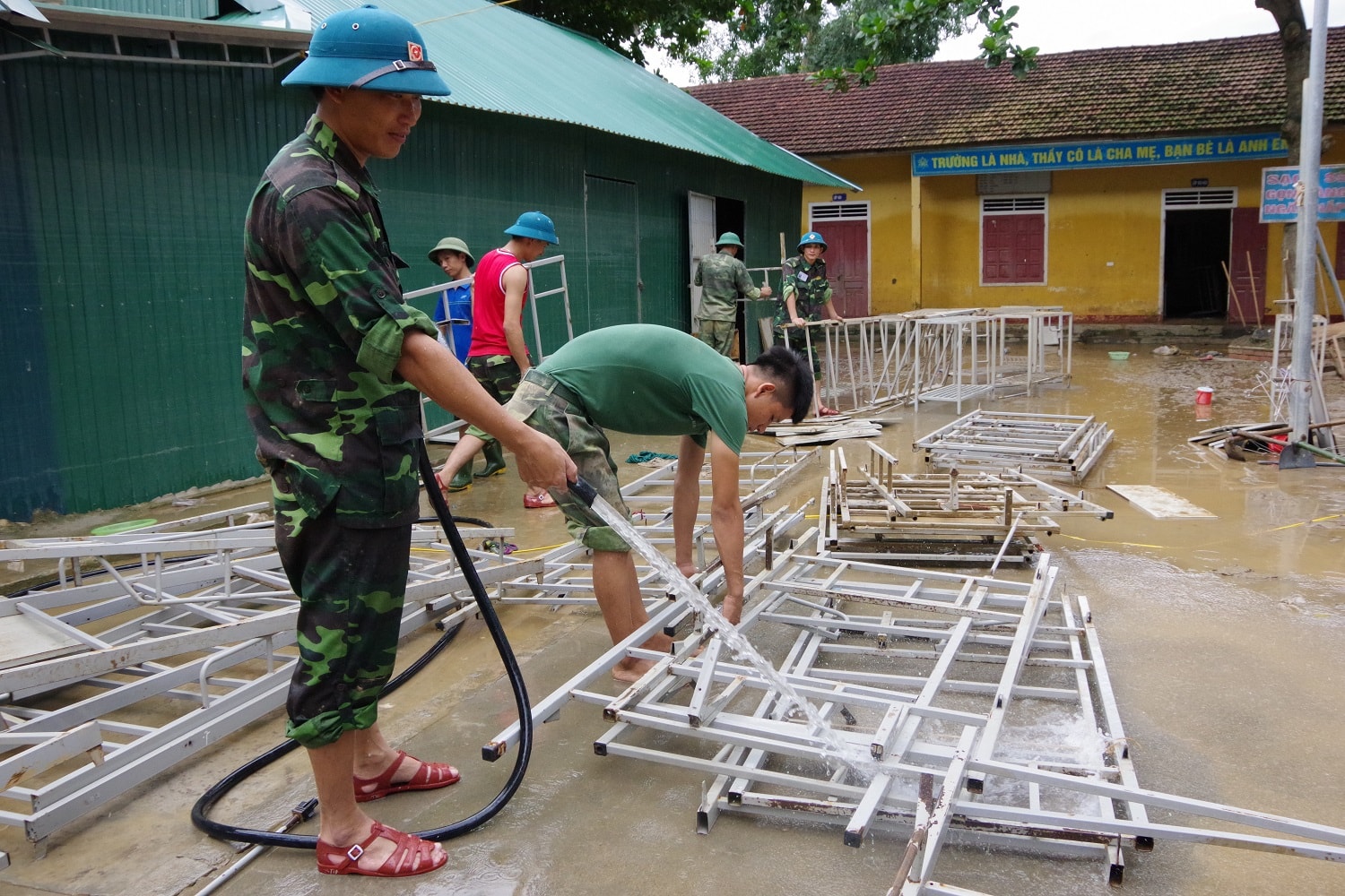 Lau chùi, rửa dọn sạch sẽ bàn ghế, giường tủ cho các cháu học sinh Trường dân tộc nội trú huyện Con Cuông. Ảnh Phong Quang