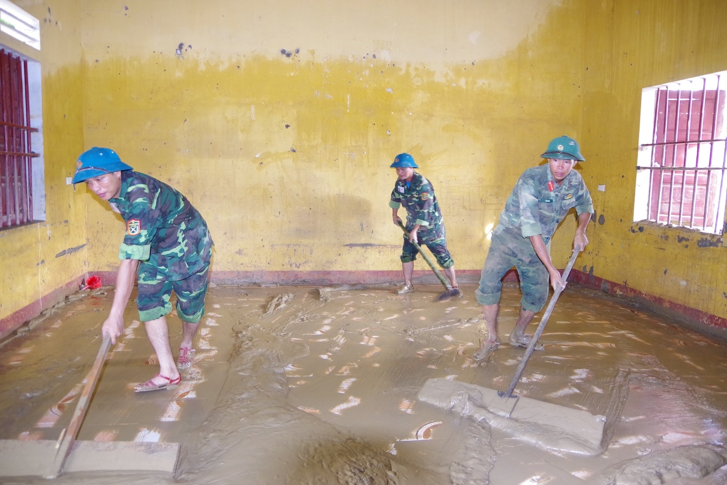 Nạo vét bùn đất tại các phòng học của Trường dân tộc nội trú huyện Con Cuông. Ảnh Trọng Kiên