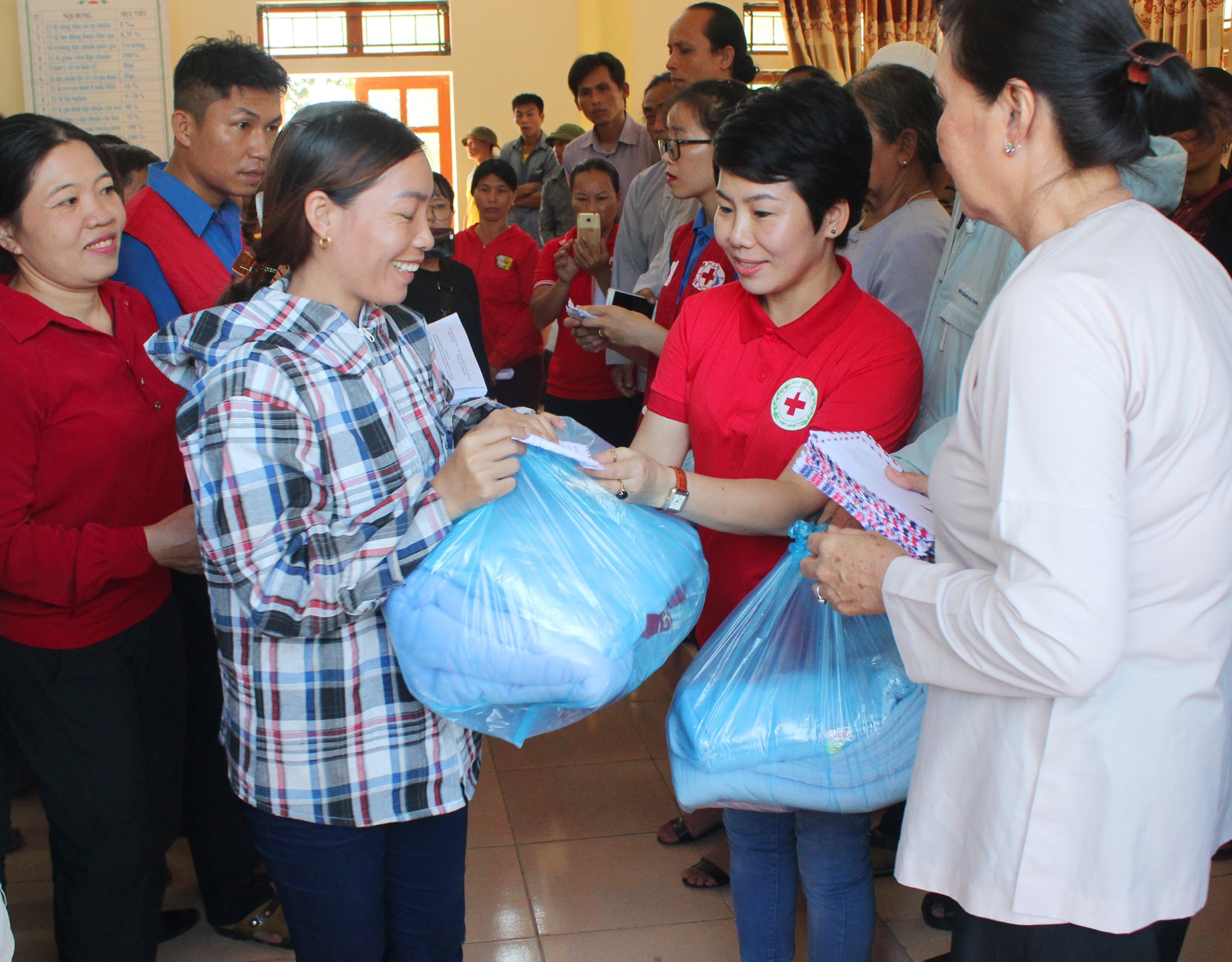 Đại diện Hội chữ thập đỏ Nghệ An trao màn và quần áo cho bà con vùng lụt Anh Sơn. Ảnh: Nguyễn Hải
