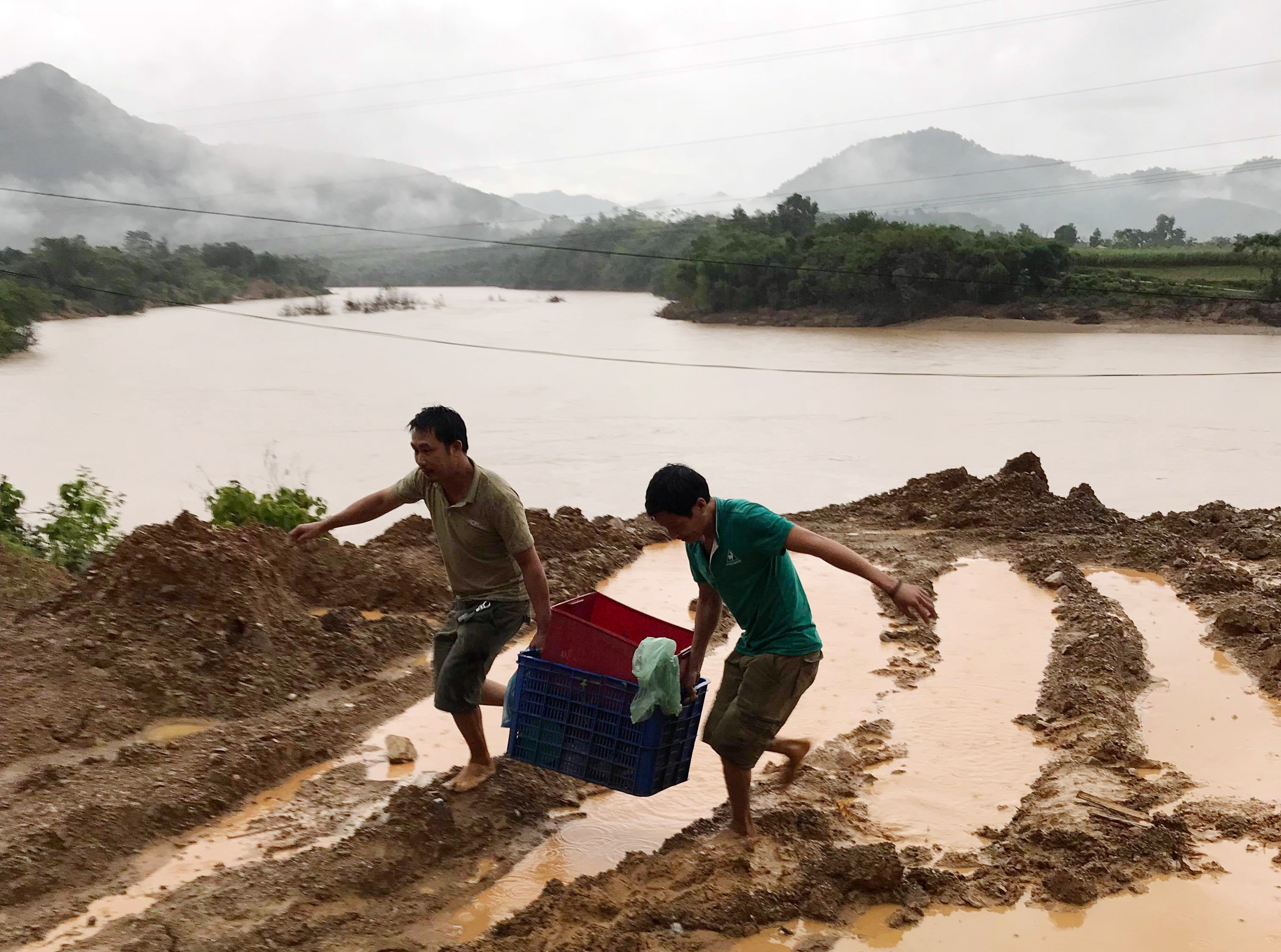 Các phương tiện không thể lưu thông, người đi đường đành phải chuyển đồ đi bộ qua vì lo ngại tắc đường kéo dài. Ảnh: KL