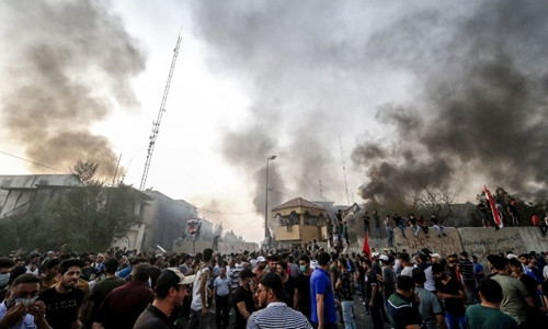 Người biểu tình tại gần một tòa nhà chính quyền bị phóng hỏa ở Basra ngày 7/9. Ảnh: AFP.