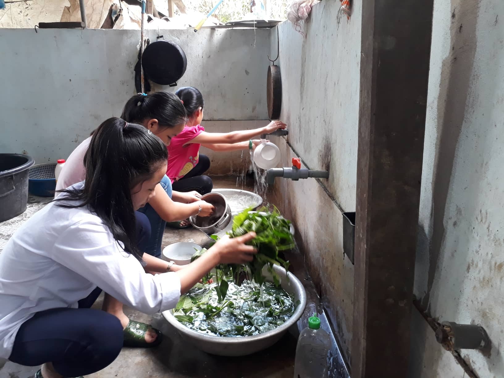Các em học sinh được người dân cho ở trọ trong nhà, cùng giúp đỡ chủ nhà chuẩn bị nấu nướng. Ảnh: Minh Hạnh