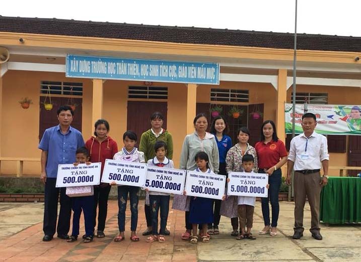 Đồng chí Nguyễn Mỹ Tặng, phó hiệu trưởng trường Chính trị Nghệ An tặng quà cho 5 em học sinh