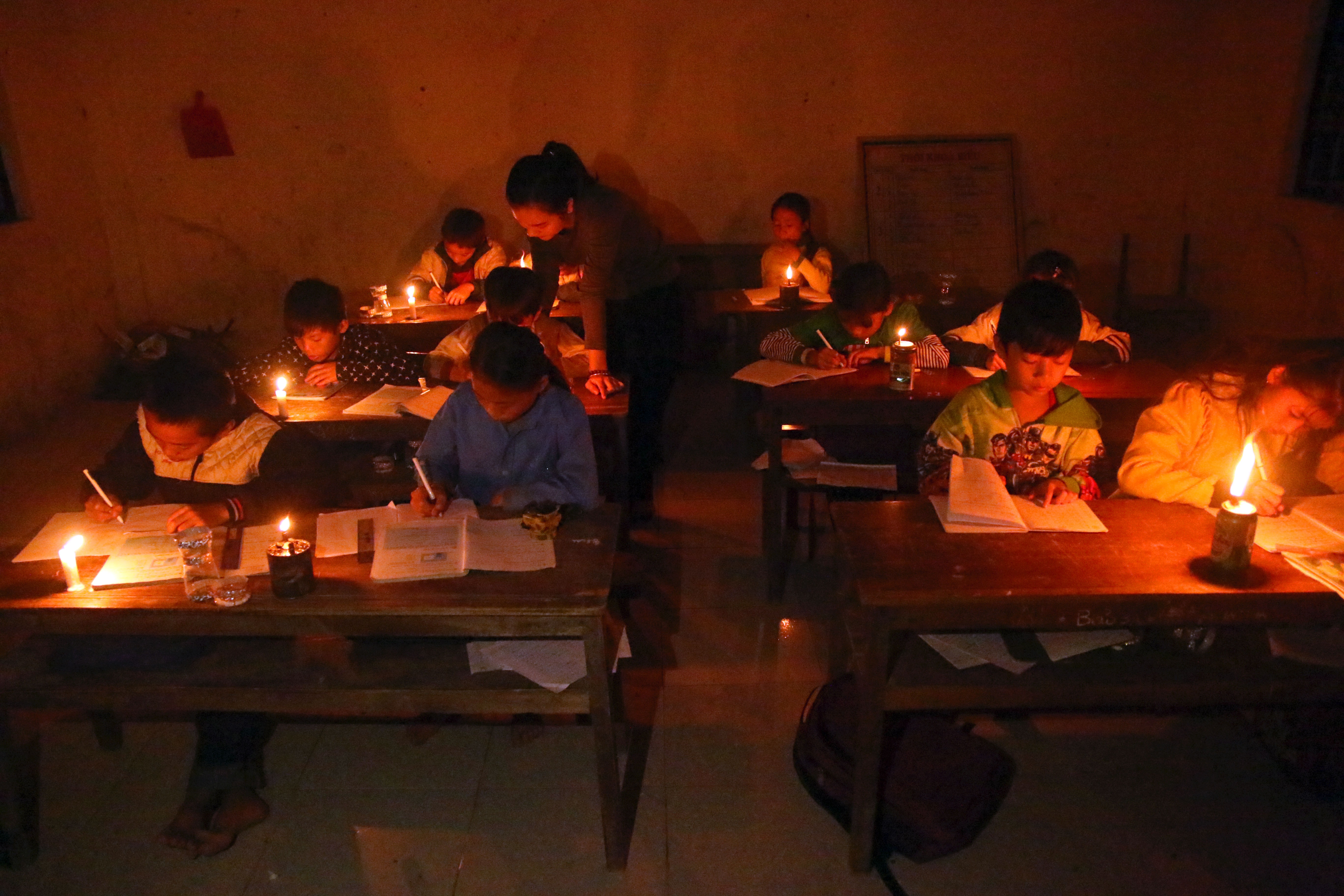 Giáo viên vùng cao thắp đèn dạy học cho học sinh. Ảnh: Đào Thọ