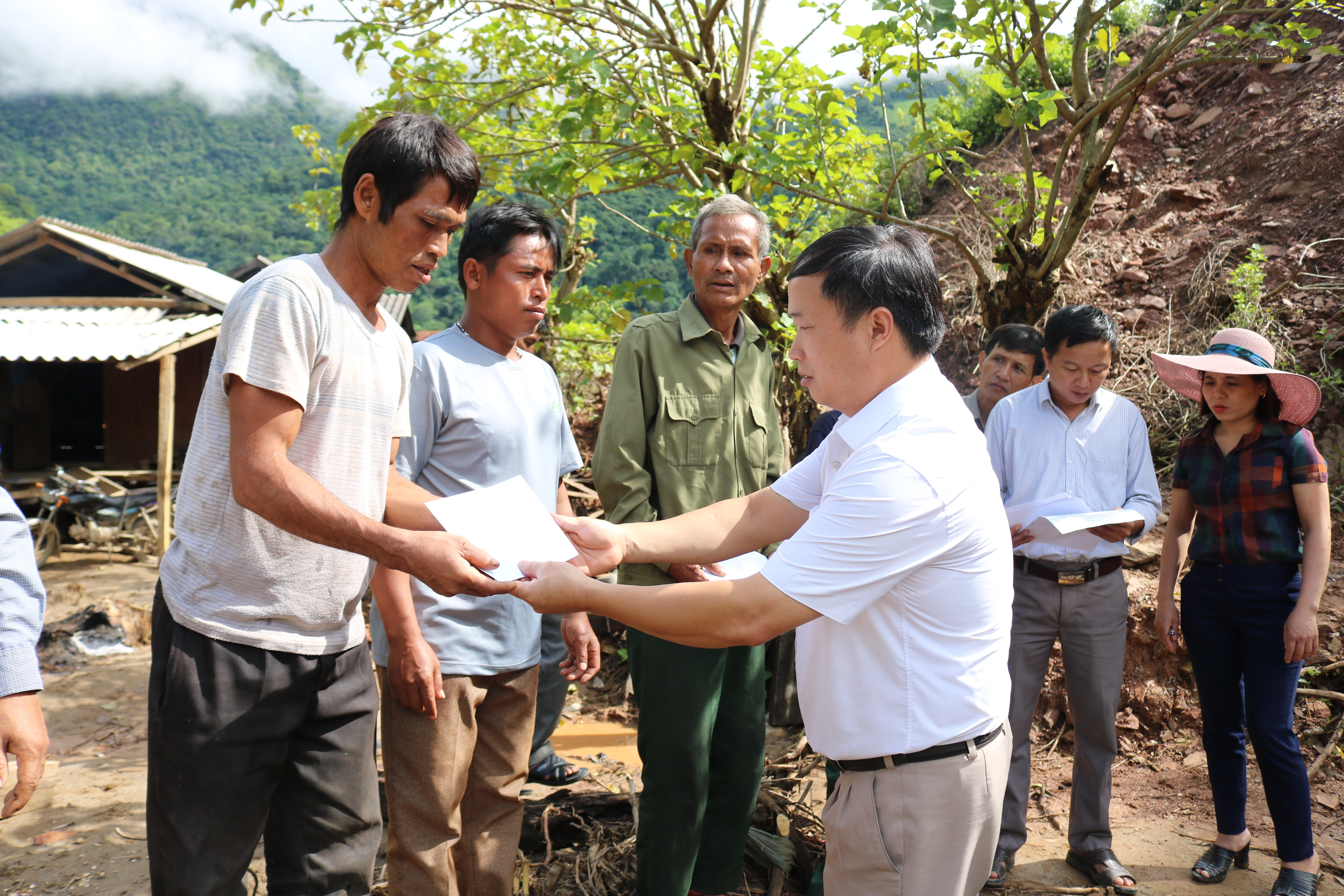 Lãnh đạo huyện Kỳ Sơn trao tiền hỗ trợ cho các hộ bị lũ cuốn trôi nhà. Ảnh: Lữ Phú