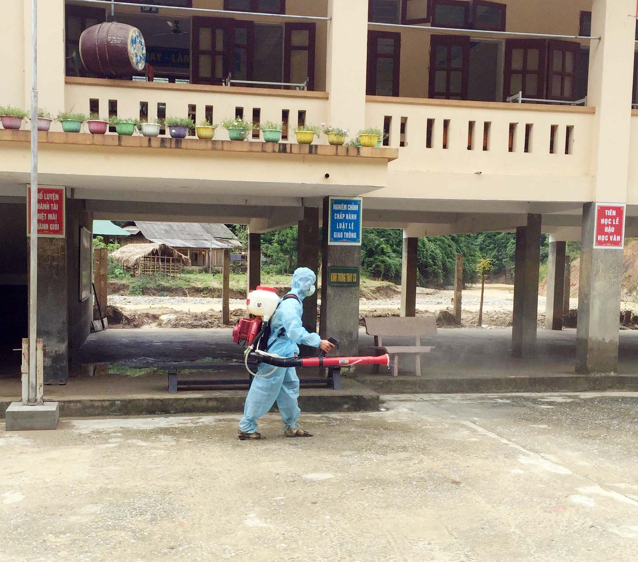 Trung tâm Y tế dự phòng huyện Tương Dương cũng cử cán bộ vào phun thuốc khử trùng các trường học và nhà dân bị ngập lụt.  Ảnh: Công Kiên