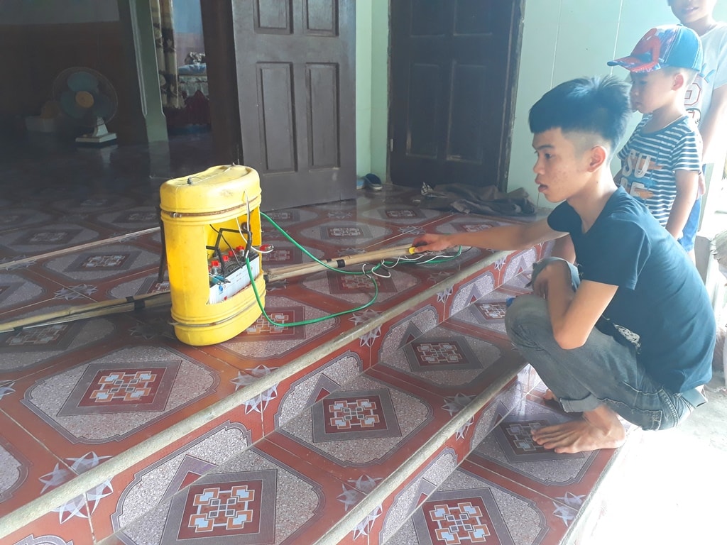 Em Nguyễn Văn H. ở xã Quỳnh Mỹ (Quỳnh Lưu) vừa trình diễn lại thao tác đánh cá vừa cho biết, nhìn đơn giản vậy thôi nhưng khi đưa hai cần xuống nước, bật công tắc sẽ xảy ra hiện tượng xung điện khiến đàn cá trong bán kính 1,5 - 2m sẽ bị điện giật chết hoặc gây thương tổn vĩnh viễn. Ảnh: Tân Bảo
