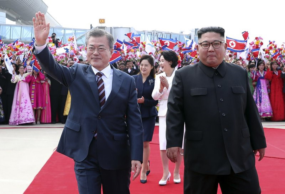 Moon Jae-in (trái) và Kim Jong-un vẫy chào người dân ở sân bay Sunan, Bình Nhưỡng sáng 18/9. Ảnh: AP