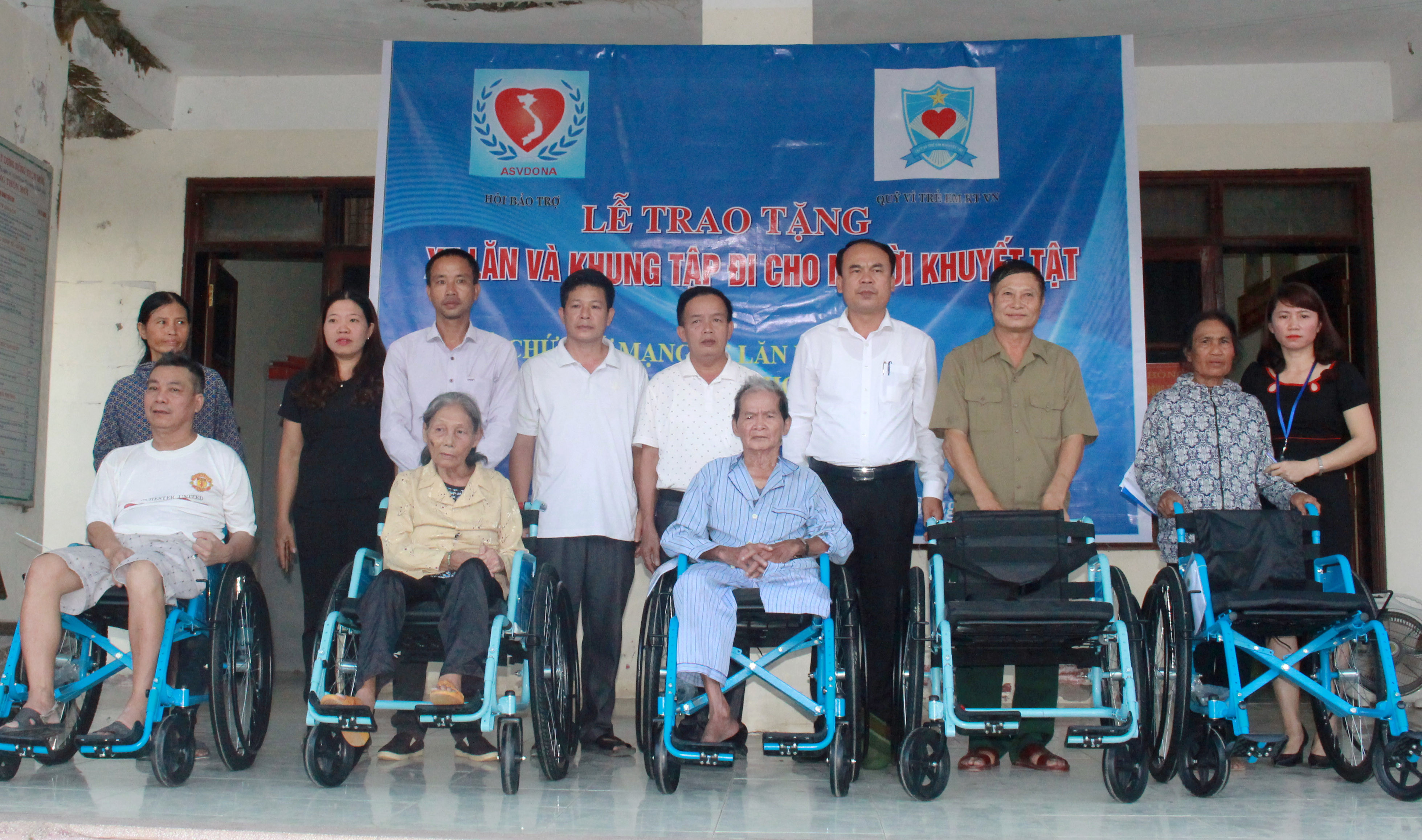 Đại diện lãnh đạo UBND huyện Anh Sơn trao xe lăn và khung tập đi cho người khuyết tật 