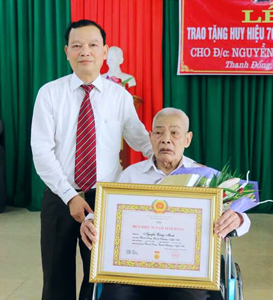 Đồng chí Nguyễn Hữu Vinh-Bí thư huyện ủy trực tiếp trao Huy hiệu 70 năm tuổi đảng cho đảng viên Nguyễn Công Minh ở Chi bộ 8 xã Thanh Đồng. Ảnh: Lan Anh