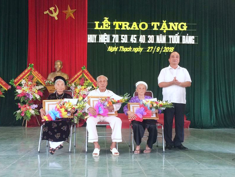 Phó Bí thư Huyện ủy Nghi Lộc Lê Văn Dũng trao Huy hiệu Đảng cho các đảng viên. Ảnh: Nhật Tuấn 