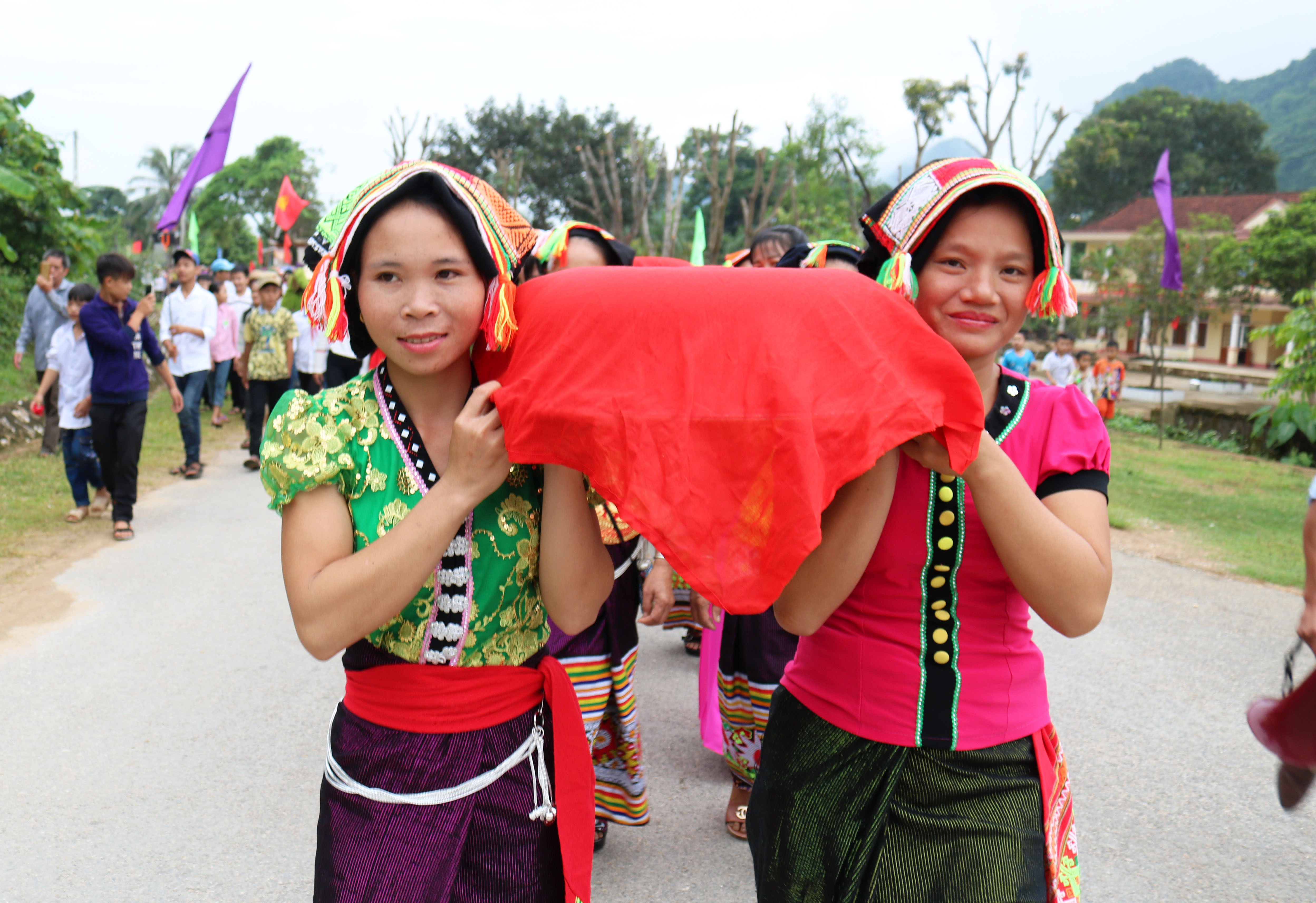 Những người phụ nữ Thái, Thổ rực rỡ trong trang phục dân tộc tham gia bưng lễ. Ảnh: Huy Thư