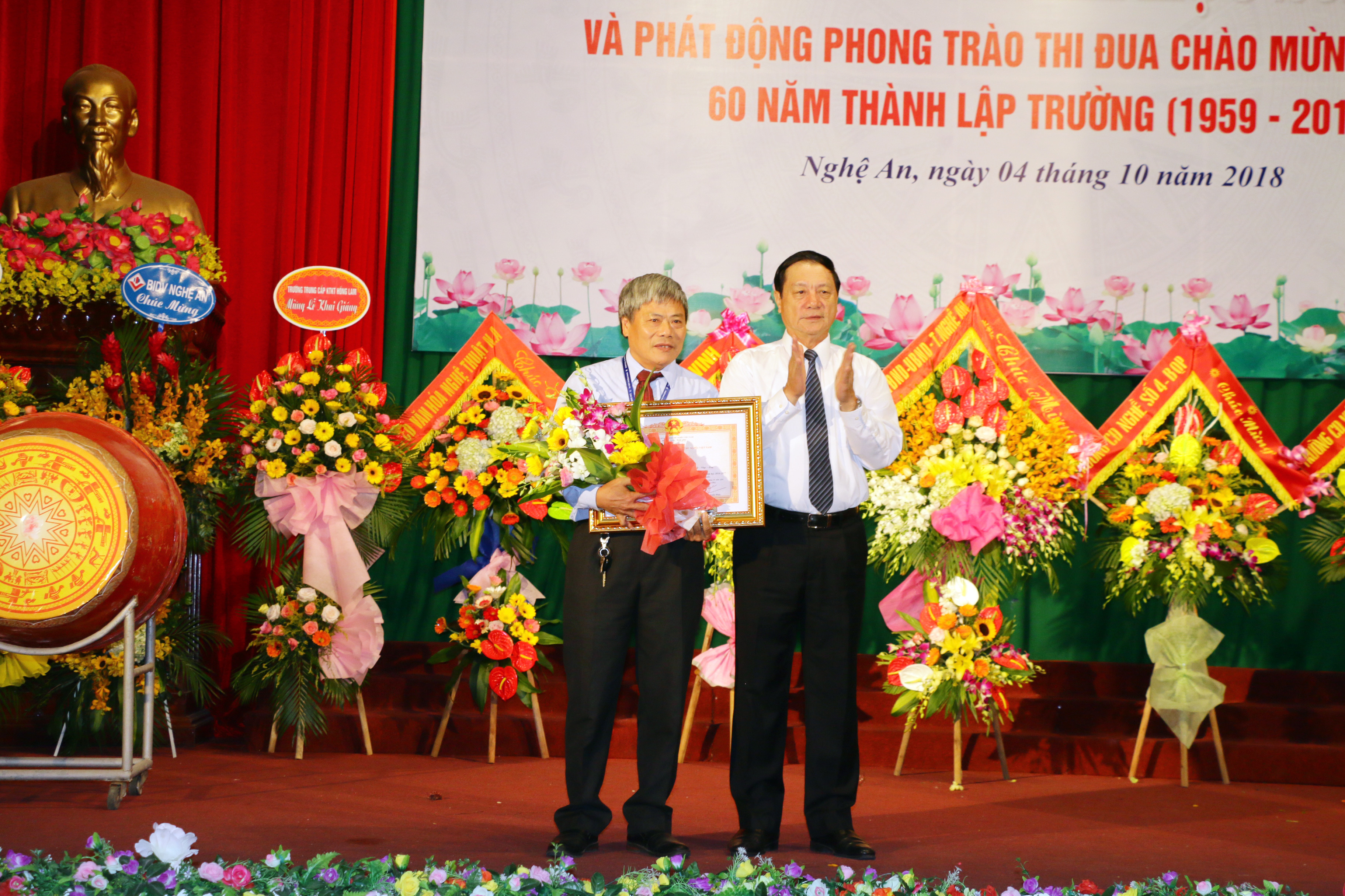 Thừa ủy quyền của Thủ tướng Chính phủ đồng chí tặng bằng khen của thủ tướng cho giảng viên của nhà trường. Ảnh: Mỹ Hà