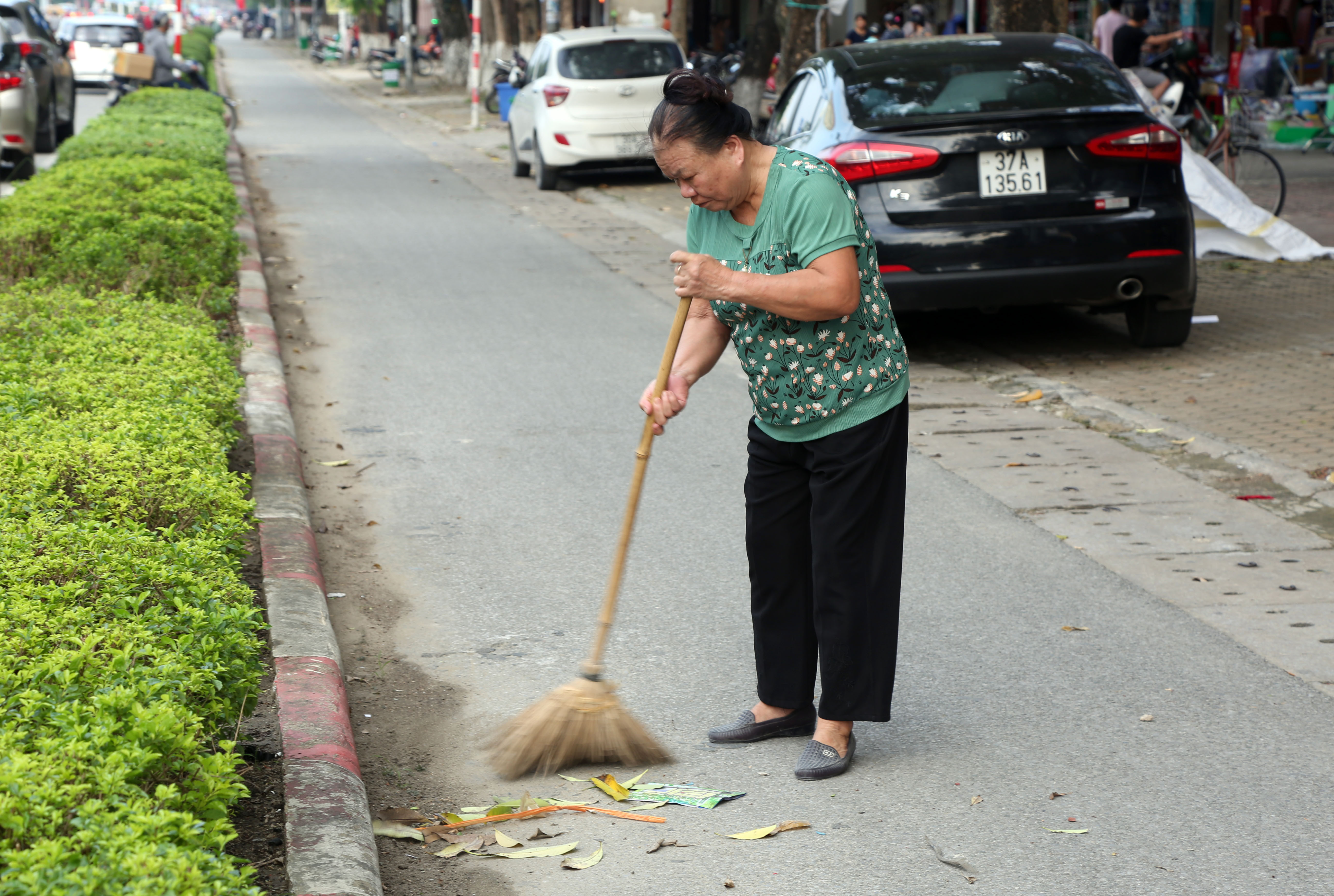 Ngày nào cũng như ngày nào, bà Hoa vẫn cần mẫn quét rác cho khu phố. Ảnh: Hoàng Hảo
