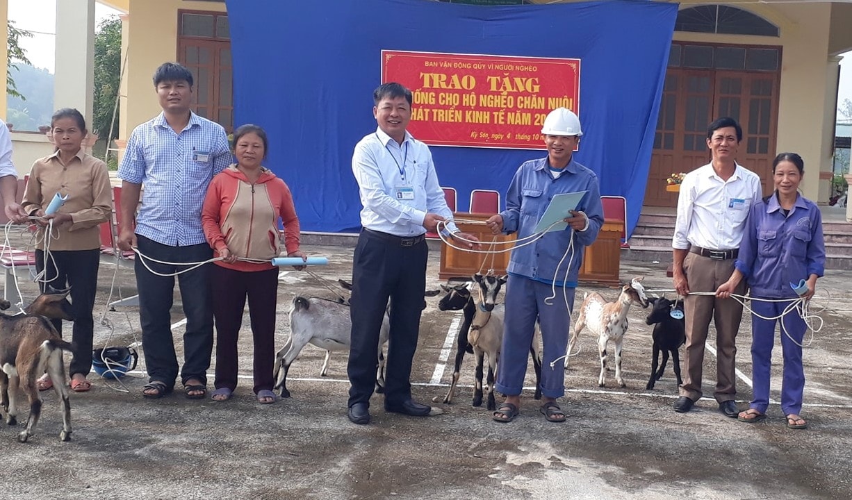 Cán bộ xã Kỳ Sơn trao vật nuôi cho hộ nghèo. Ảnh Cẩm Tú