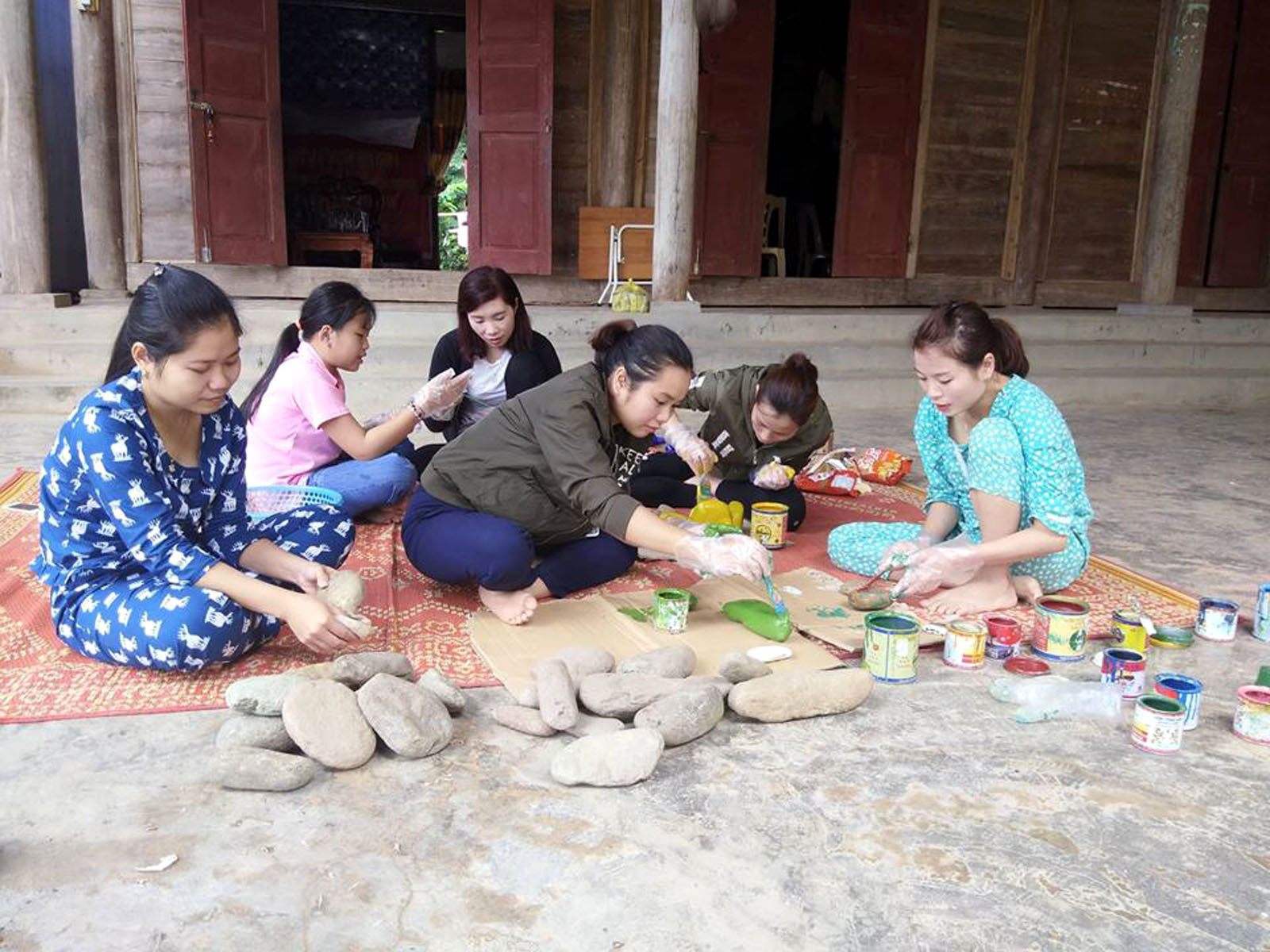 Tranh thủ ngày nghỉ giáo viên trường Mầm non Mai Sơn (Tương Dương) làm đồ chơi cho trẻ từ đá suối. Ảnh: Đình Tuân