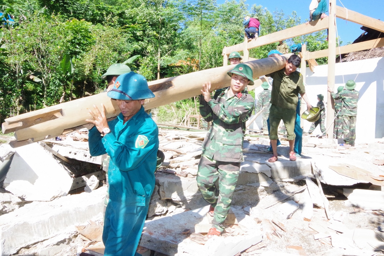 Cán bộ, chiến sỹ Ban CHQS huyện Tương Dương giúp gia đình ông Lô Văn Tiến ở bản Vẽ, xã Yên Na di dời nhà bị sập do mưa lũ. Ảnh: Phong Quang 