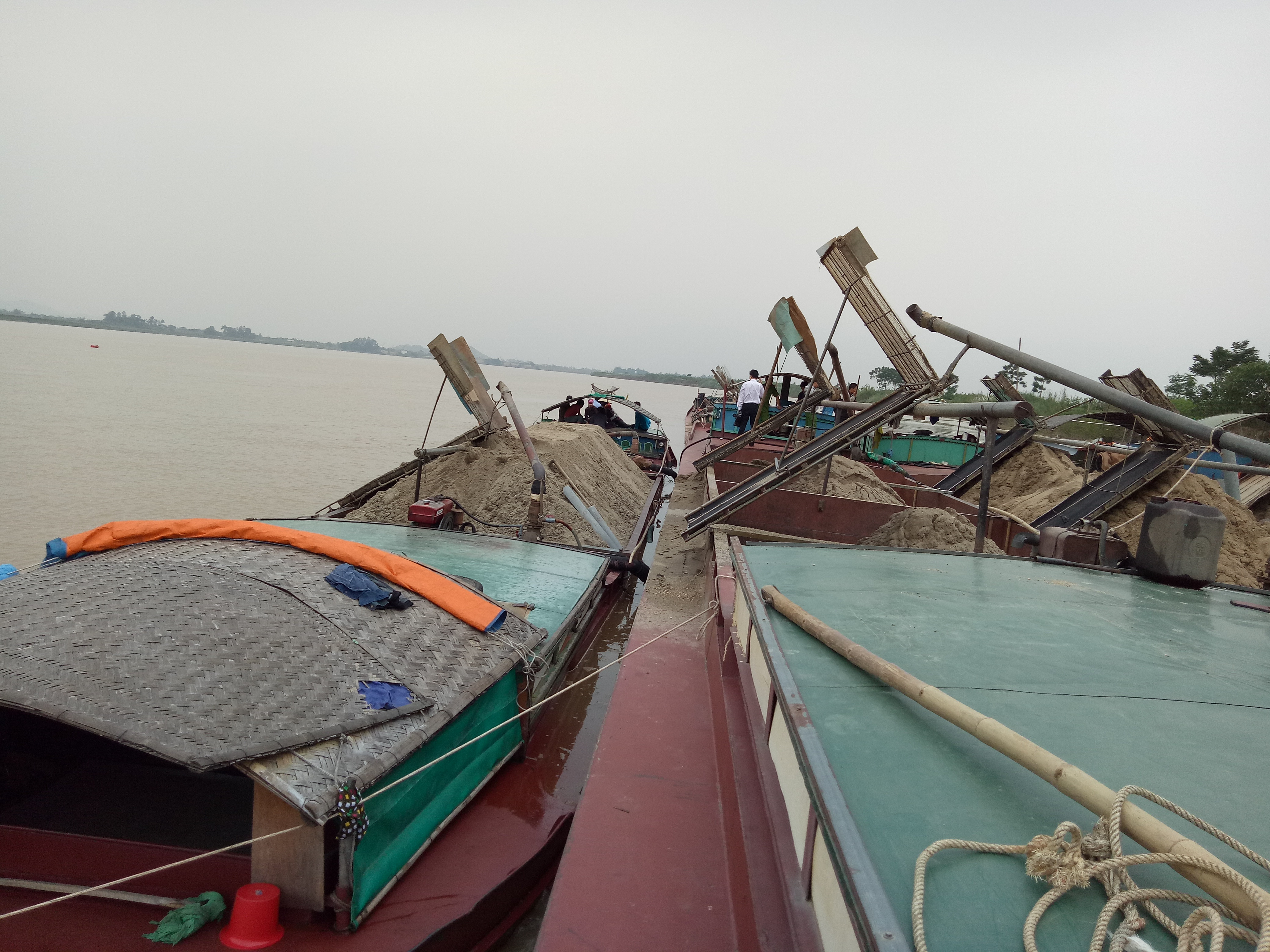 Các thuyền khai thác cát trái phép trên sông Lam, đoạn qua địa bàn xã Khánh Sơn, Nam Đàn bị bắt giữ. Ảnh: Thúy Tình