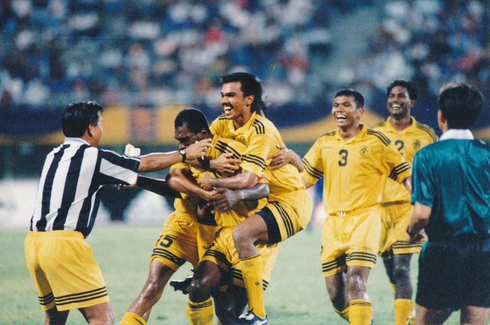 Cầu thủ đầu tiên ghi bàn tại giải đấu: K. Sanbagaraman (Malaysia). AFF Cup, giải bóng đá lớn nhất ở khu vực Đông Nam Á bắt đầu diễn ra từ năm 1996. Sau 75 phút thi đấu, Tiger Cup (tiền thân của AFF Cup) mới có bàn thắng mở màn do pha lập công của Sanbagaraman vào lưới đội chủ nhà Singapore. Thế nhưng gần 44.000 khán giả nhà vẫn được nở nụ cười sau khi Fandi Ahmad có bàn thắng gỡ hòa vào phút cuối cùng của trận đấu. Tuy nhiên, Singapore sau đó vẫn bị loại từ vòng bảng, trong khi Malaysia tiến vào vòng bán kết. Ảnh: AFF Cup.