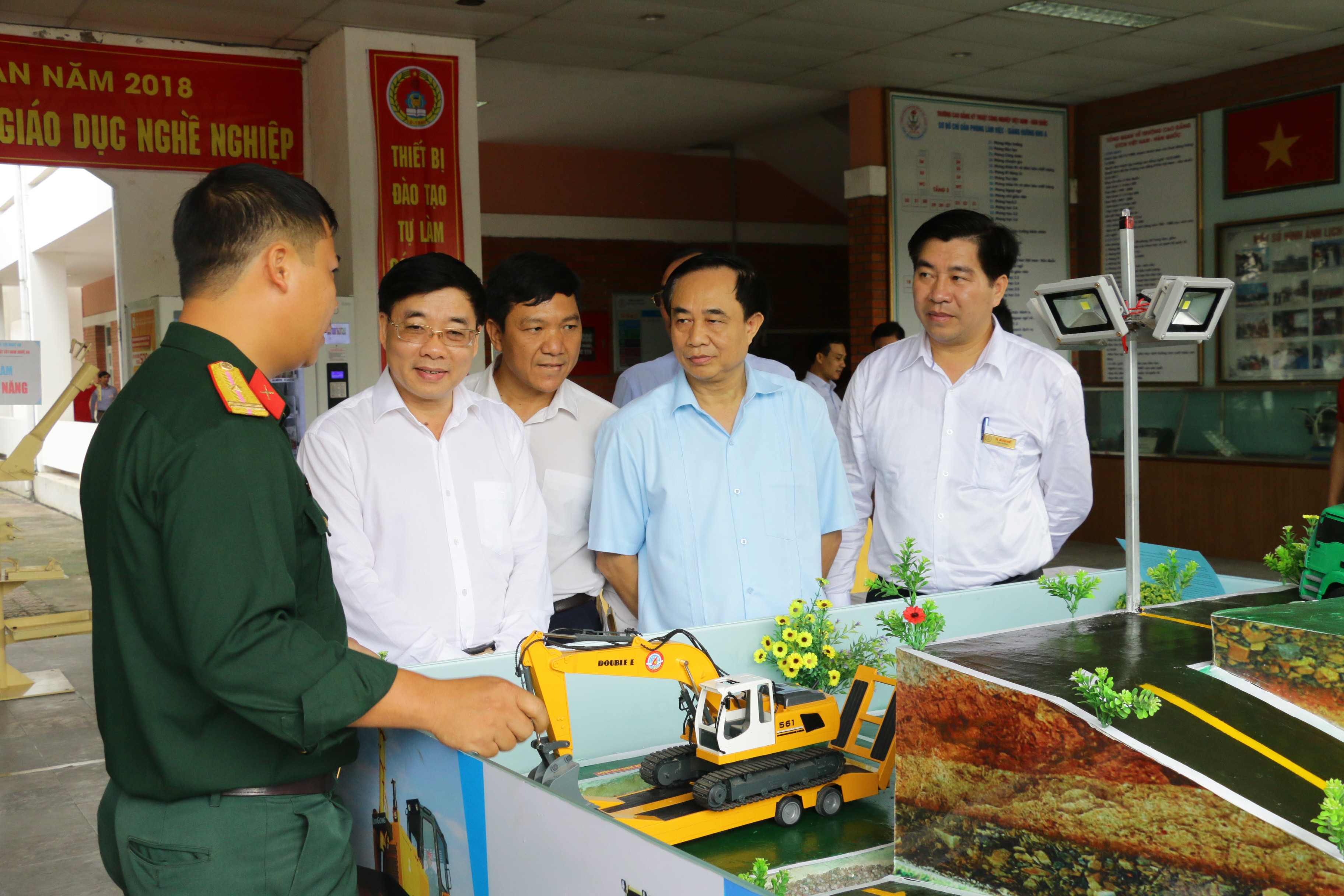 Đồng chí Nguyễn Văn Thông tham quan gian trưng bày thiết bị tự làm của Trường Cao đẳng nghề số 4 Bộ Quốc phòng - Sa bàn huấn luyện lái máy xúc. Ảnh: Mỹ Hà