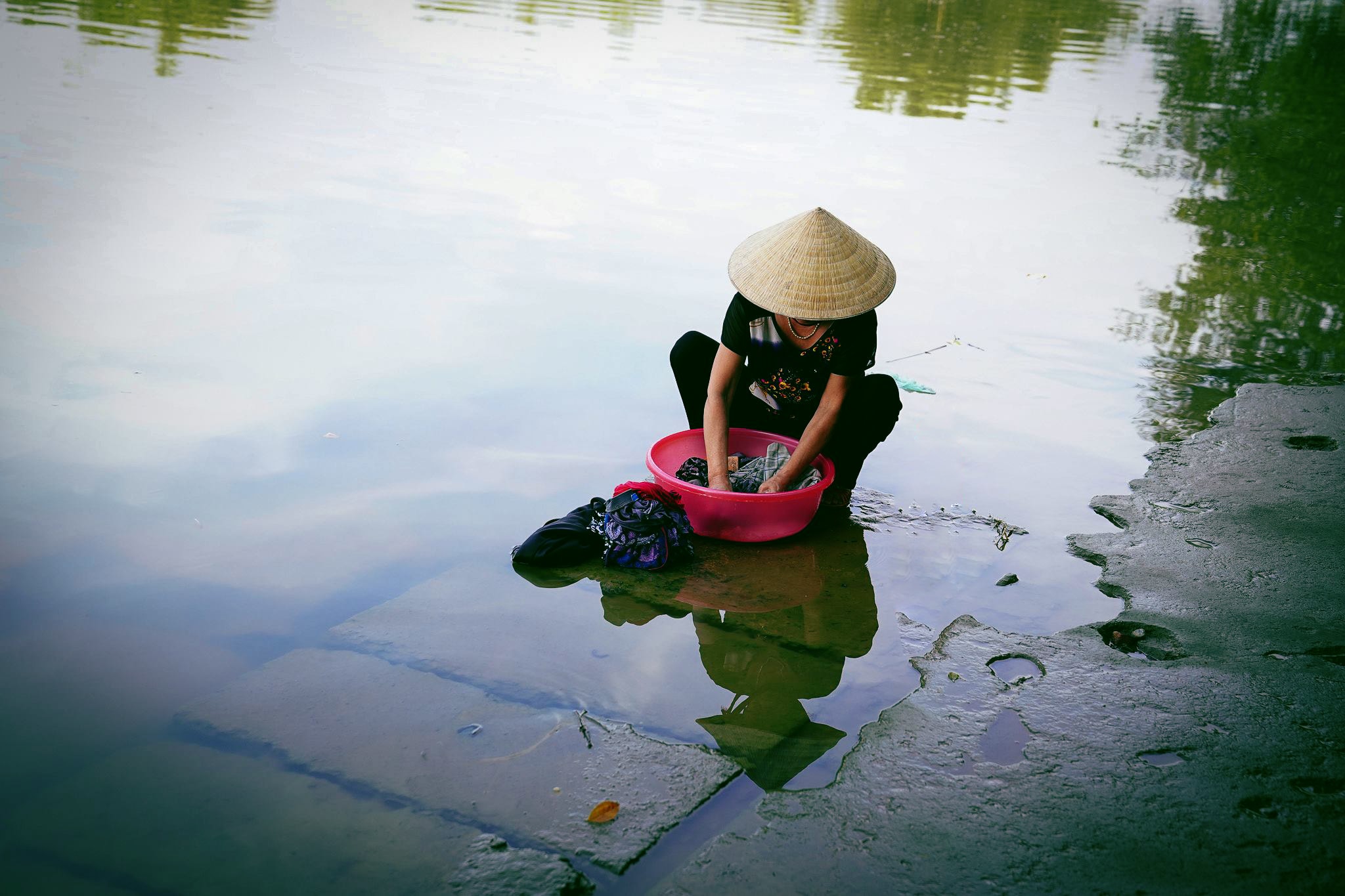  Mặc cho nhịp sống hiện đại đã tràn vào từng làng quê, những người phụ nữ vẫn gắn bó với góc sông hàng ngày. Ảnh: Hồ Chiến