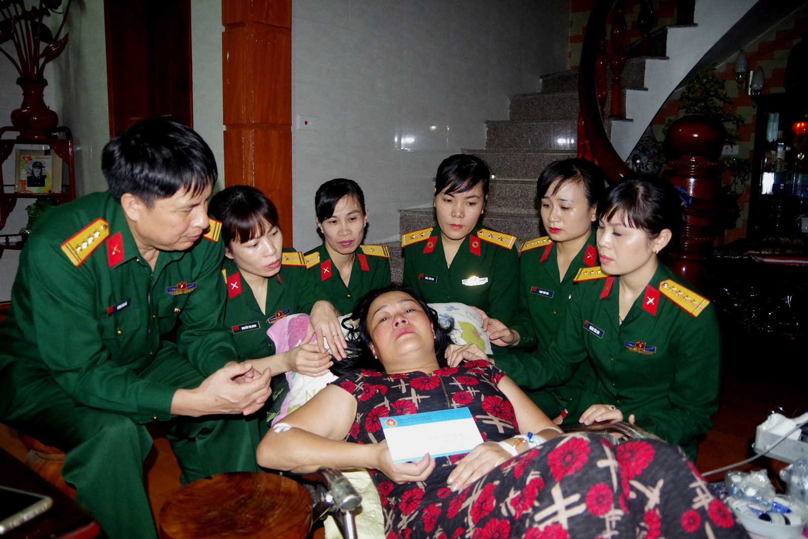Đại tá Vương Kim Hải - Phó Chính ủy và cán bộ, hội viên Hội Phụ nữ Bộ CHQS tỉnh đến thăm, tặng quà động viên hội viên Nguyễn Lam Giang bị bệnh tật. Ảnh: Hoàng Anh
