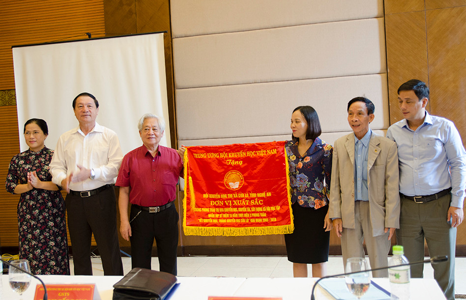 Đồng chí Lê Minh Thông và Phạm Tât Dong trao cờ thi đua cho Hội Khuyến học thị xã Cừa Lò. Ảnh: Mỹ Hà