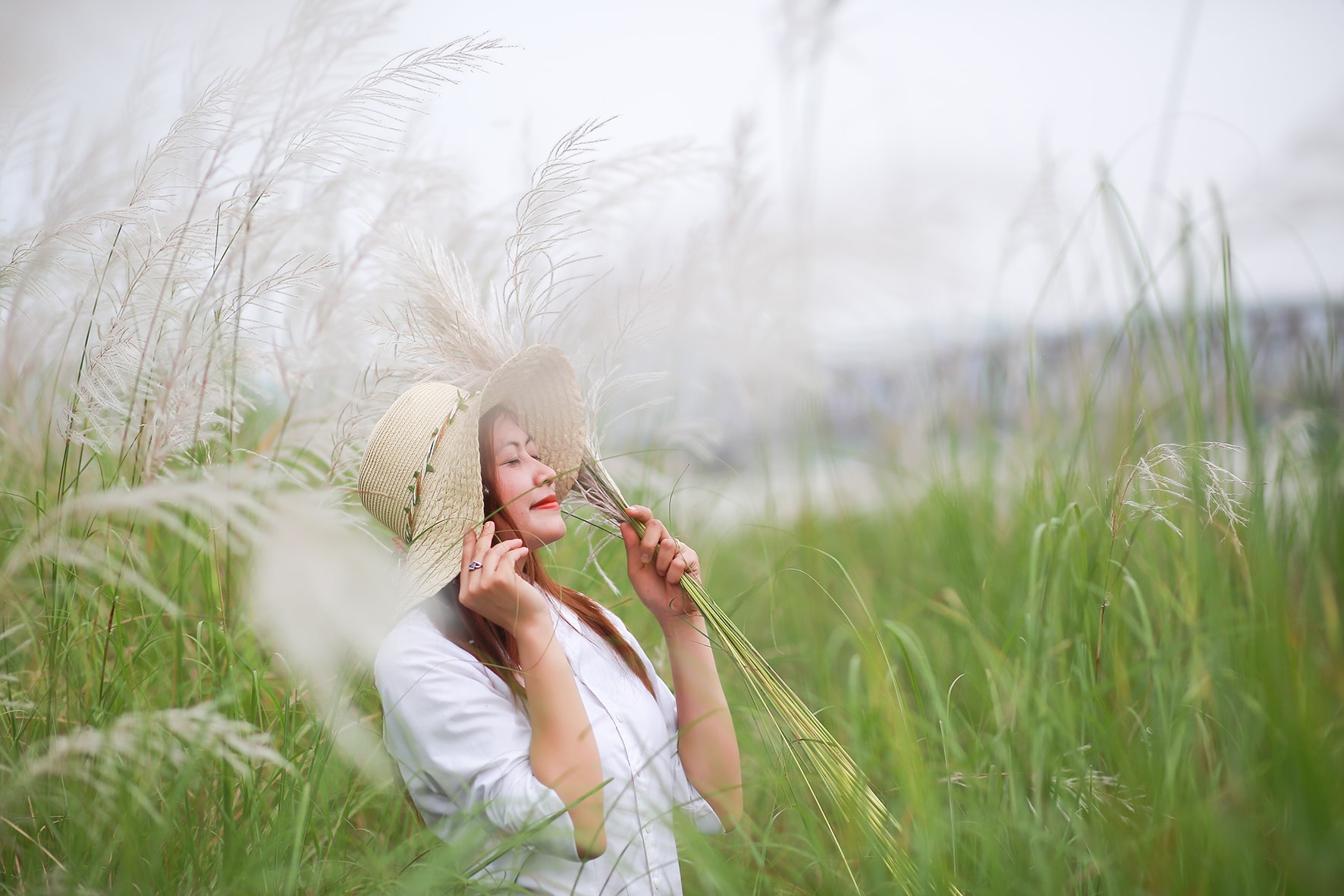 Cô gái làm duyên bên những bông lau nguyên sơ và trinh bạch. Ảnh: Sách Nguyễn