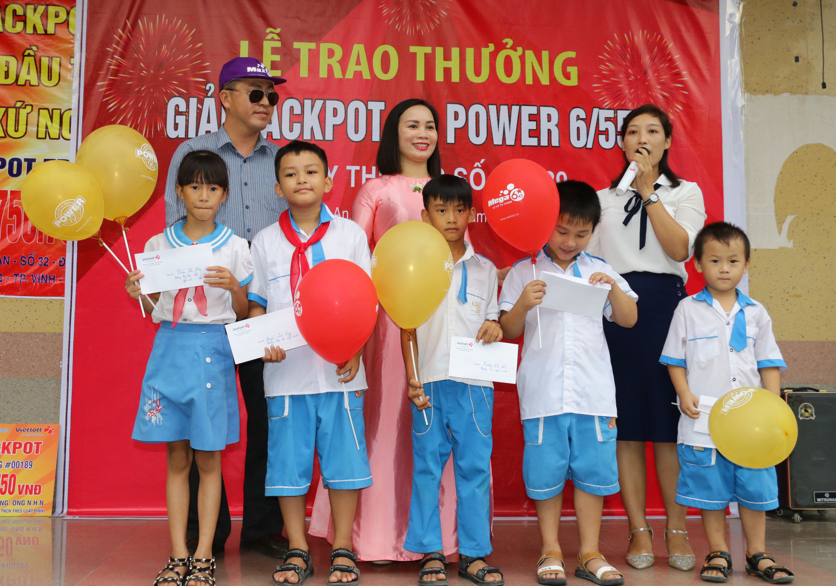 Đại diện công ty và khách hàng trúng thưởng tặng quà cho học sinh huyện Nghi Lộc. Ảnh: Mỹ Hà