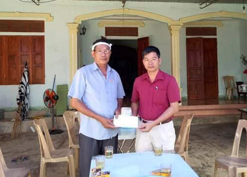 Đại diện Ủy ban MTTQ huyện trao số tiền hỗ trợ 5 triệu đồng cho gia đình, ảnh Bông mai.