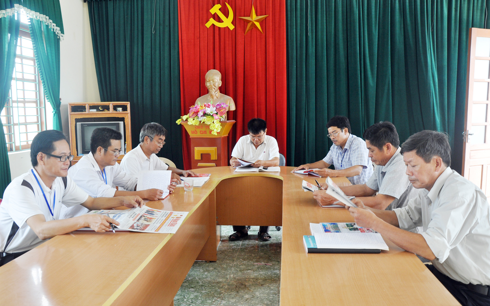 Ông Đặng Xuân Nam (ngồi giữa, hàng bên phải) tham gia buổi giao ban của đội ngũ truyên truyền viên của xã Nam Sơn (Đô Lương). Ảnh: Công Khang