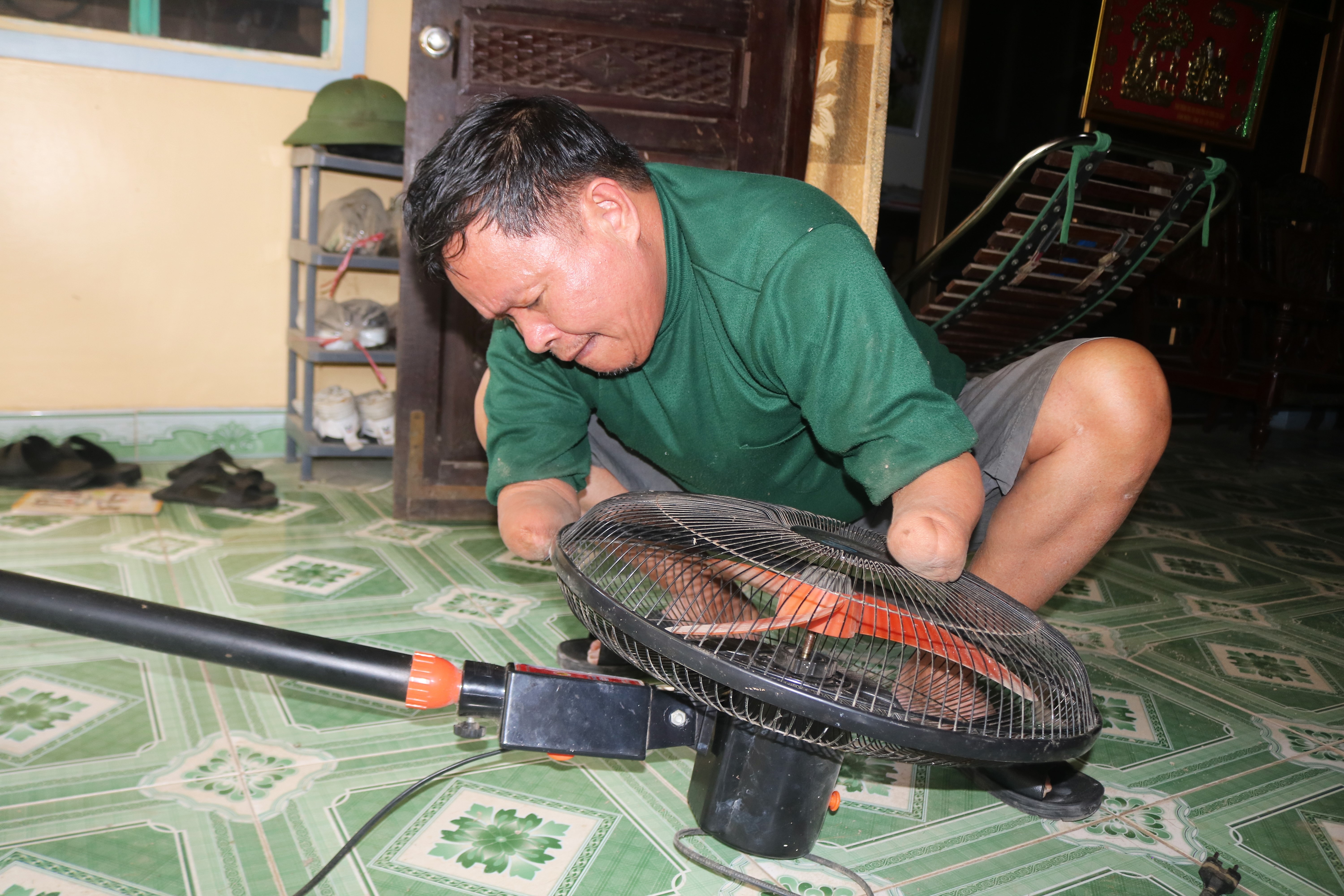 Việc cầm nắm, bưng bê không có gì khó đối với người thương binh giàu nghị lực. ảnh 5: “Để có thể sử dụng đôi tay như một người bình thường là điều không thể nhưng trong “cái khó thường ló cái khôn”, trước khi làm việc gì đó phải suy nghĩ, tính toán để tìm ra cách giải quyết. Đi xe đạp quan trọng nhất là giữ thăng bằng, ngày xưa đường đất khó đi, qua những đoạn ổ gà nếu mình ngồi trên yên xe sẽ bị mất tay lái ngay nên mình phải nghĩ ra cách đứng trên bê đan, trọng lượng cơ thể sẽ ở trên 2 bê đan cho nên sẽ không bao giờ ngã” – Ông Linh bật mí.