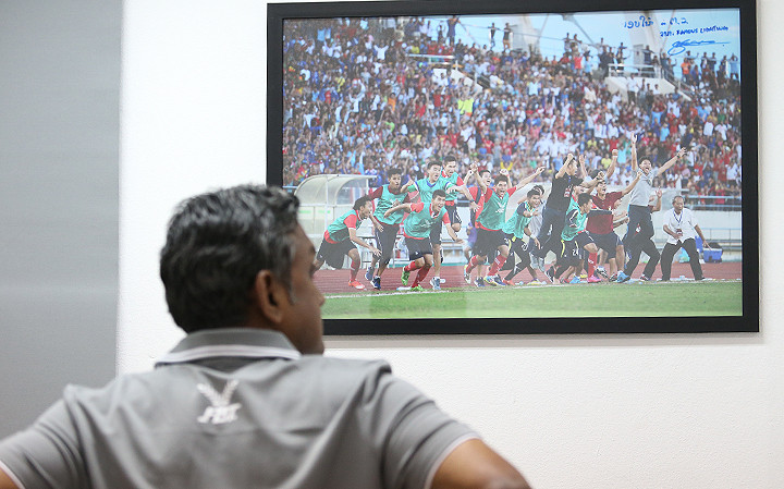 ÔngSundramoorthy đứng ngắm bức tranh ghi khoảnh khắc chiến thắng của bóng đá trẻ Lào tại trụ sở Liên đoàn bóng đá Lào chiều 6/11. Ảnh: Lâm Thỏa