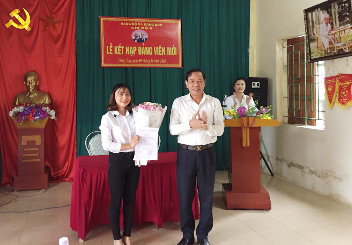 Giám đốc Sở Giao thông vận tải Nguyễn Hồng Kỳ tặng hoa chúc mừng đảng viên mới Trần Thị Ngọc Anh. Ảnh Lê Thanh