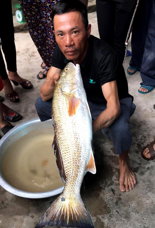 Anh Hoàng Văn Bắc và con cá vừa câu được. Ảnh: Huy Thư