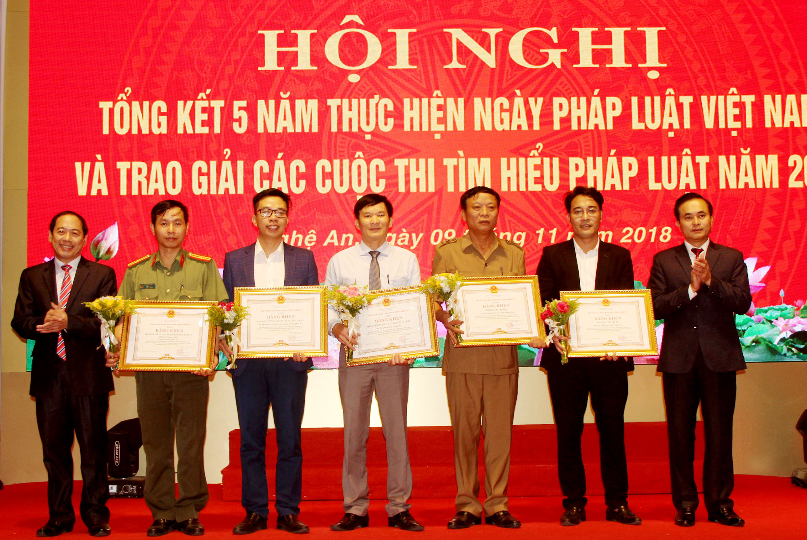 Đồng chí Lê Ngọc Hoa trao Bằng khen của UBND tỉnh cho 5 tập thể có thành tích trong 5 năm tổ chức Ngày Pháp luật Việt Nam. Ảnh: Phạm Bằng
