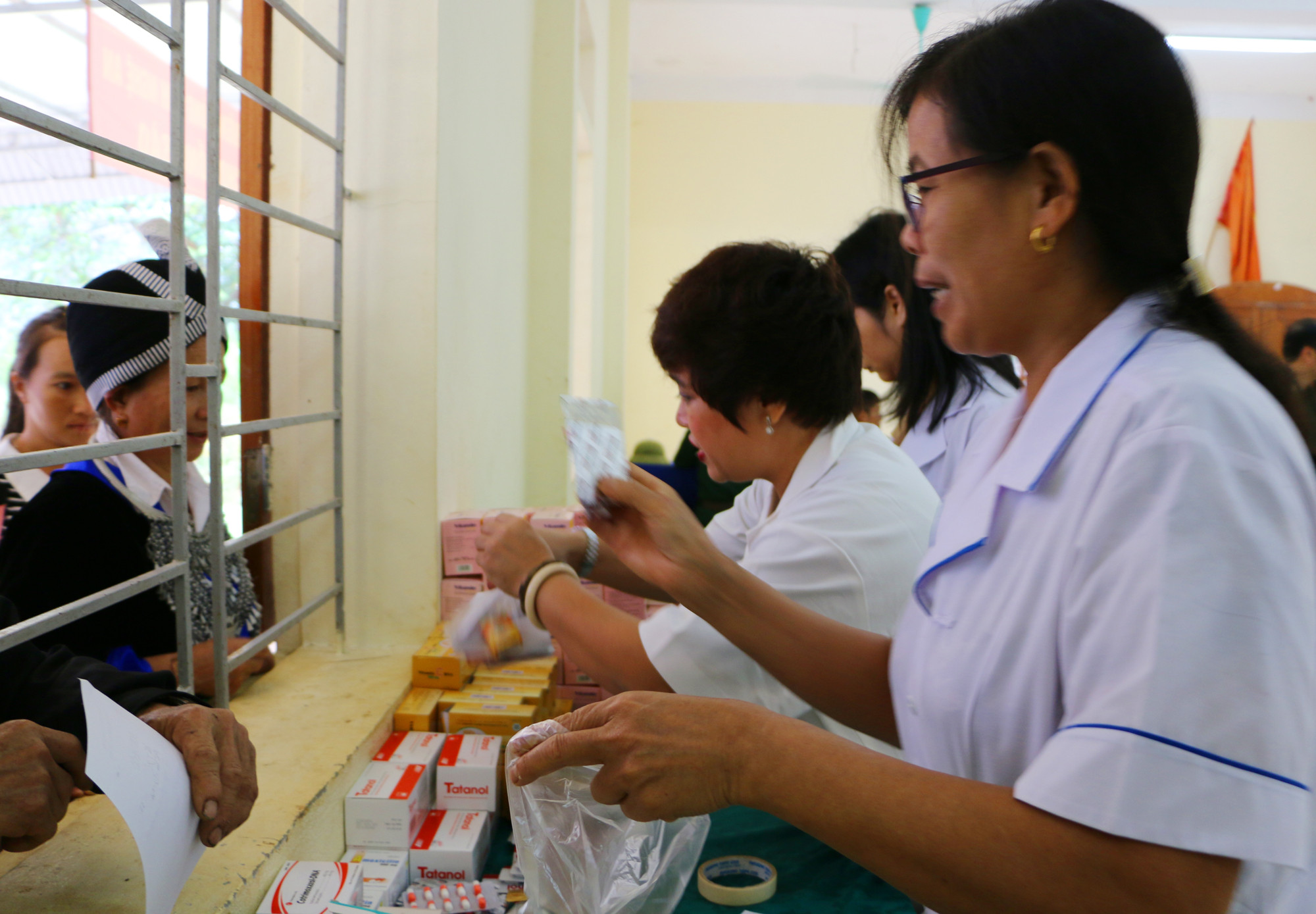 Đoàn công tác cấp thuốc miễn phí cho bà con sau khi được khám bệnh. Ảnh: Nguyễn Hải