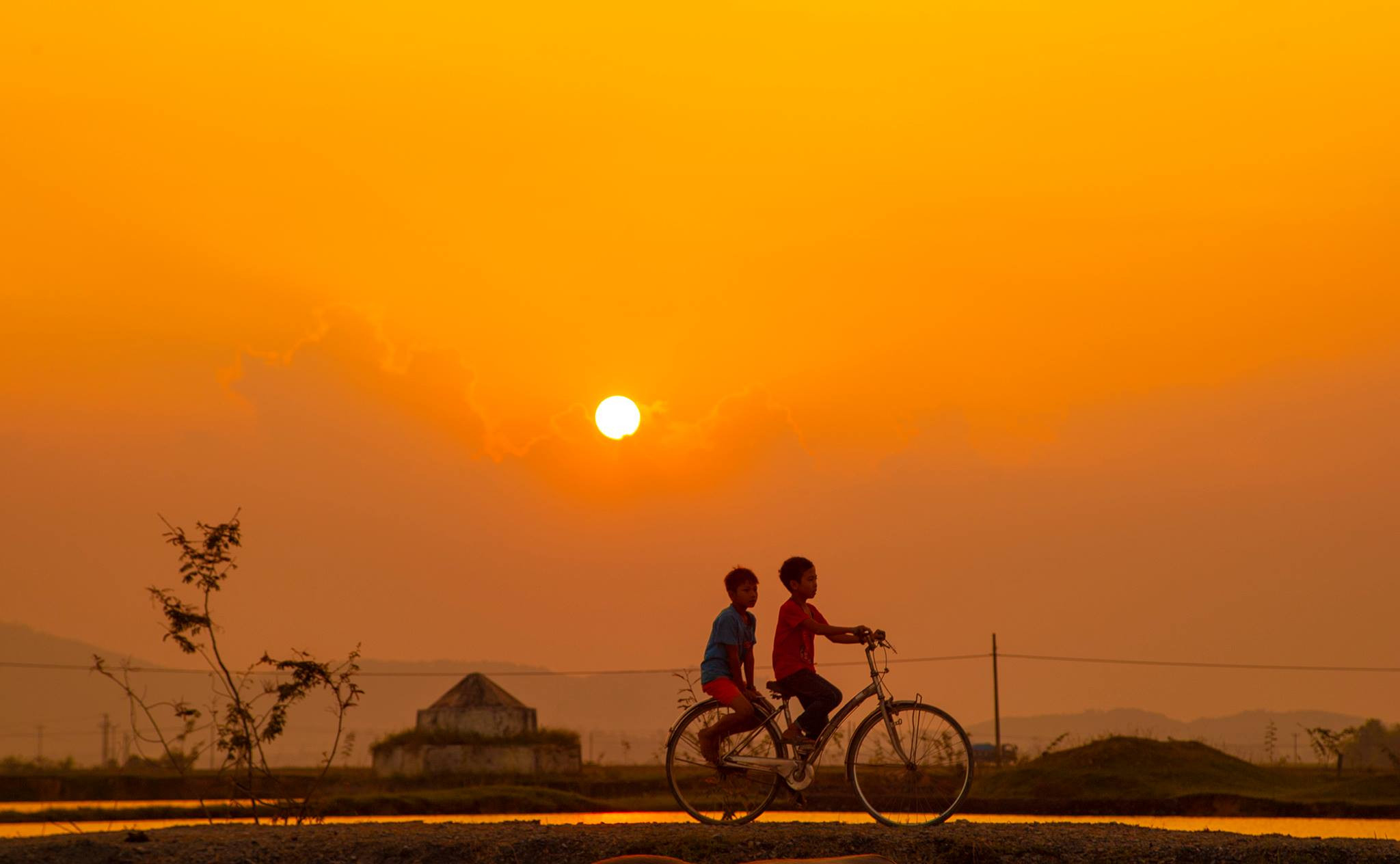 Tiếng nói cười của lũ trẻ lanh lảnh trên con đường đê nhuộm ánh hoàng hôn. Ảnh: Nguyễn Đạo