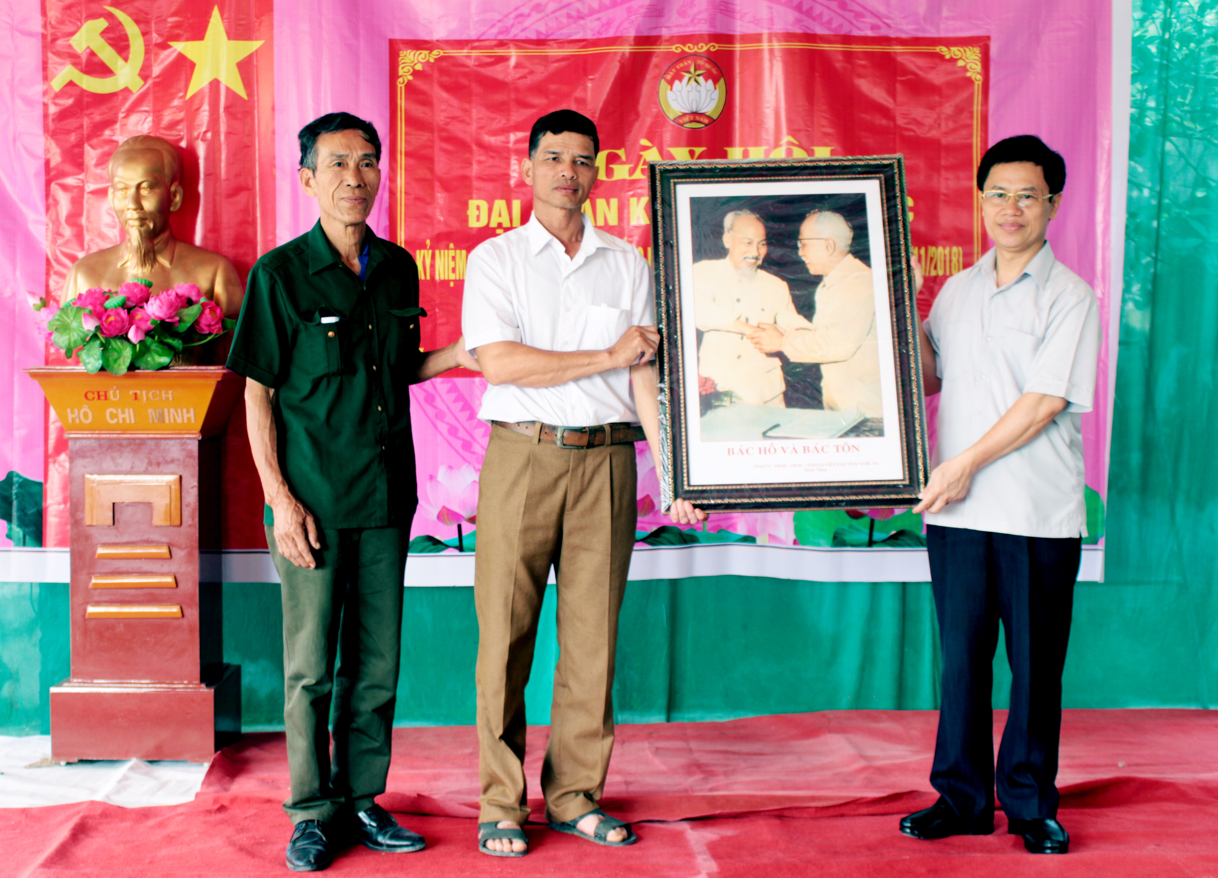 Phó Bí thư Thường trực Nguyễn Xuân Sơn trao tặng xóm 6 xã Nghi Phương (Nghi Lộc) bức ảnh Bác Hồ và Bác Tôn. Ảnh Thanh Lê