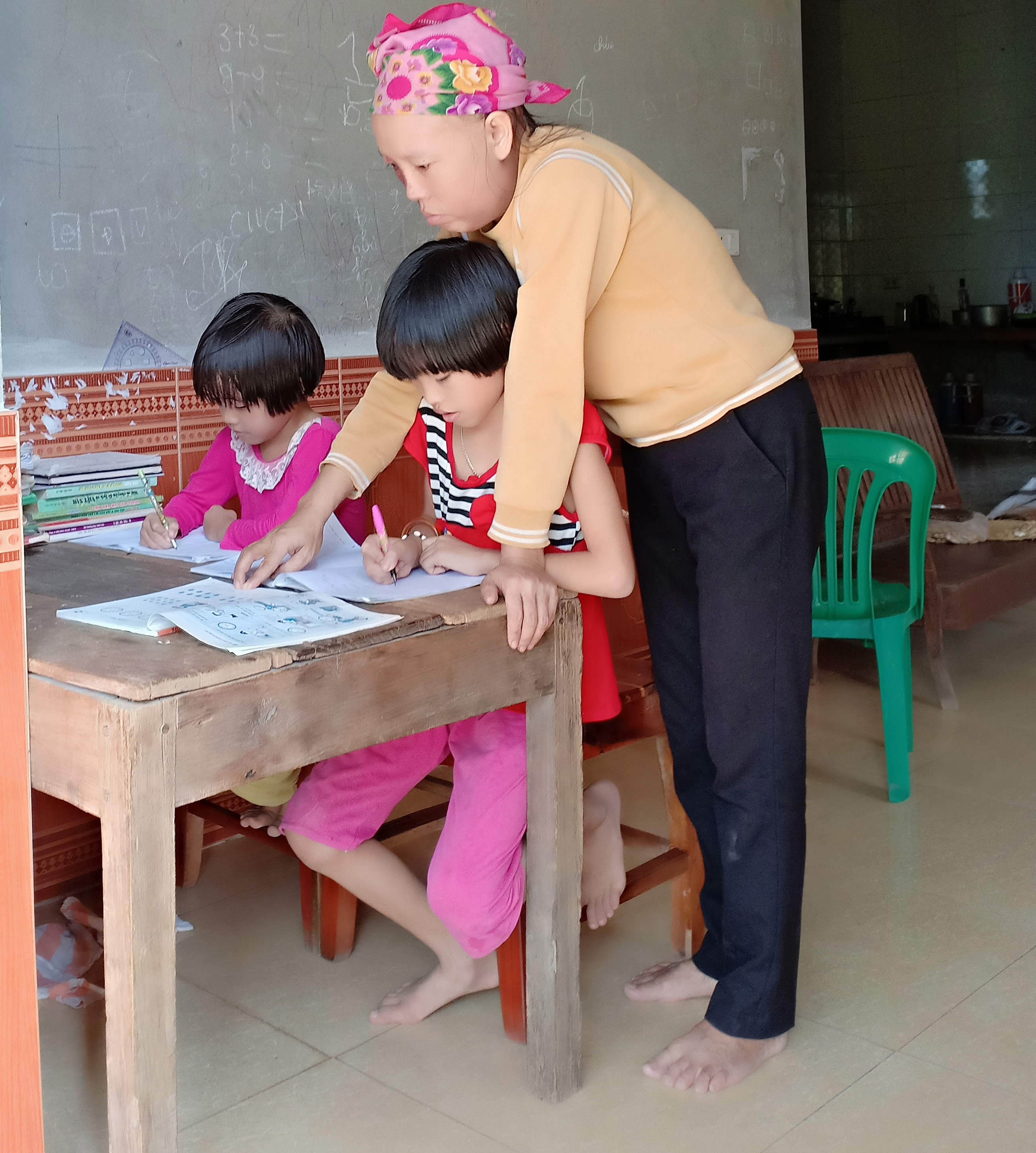 Hai con còn quá nhỏ nên dù ốm nặng, Hà vẫn phải cáng đáng việc nhà, chăm sóc các con. Ảnh: T.P