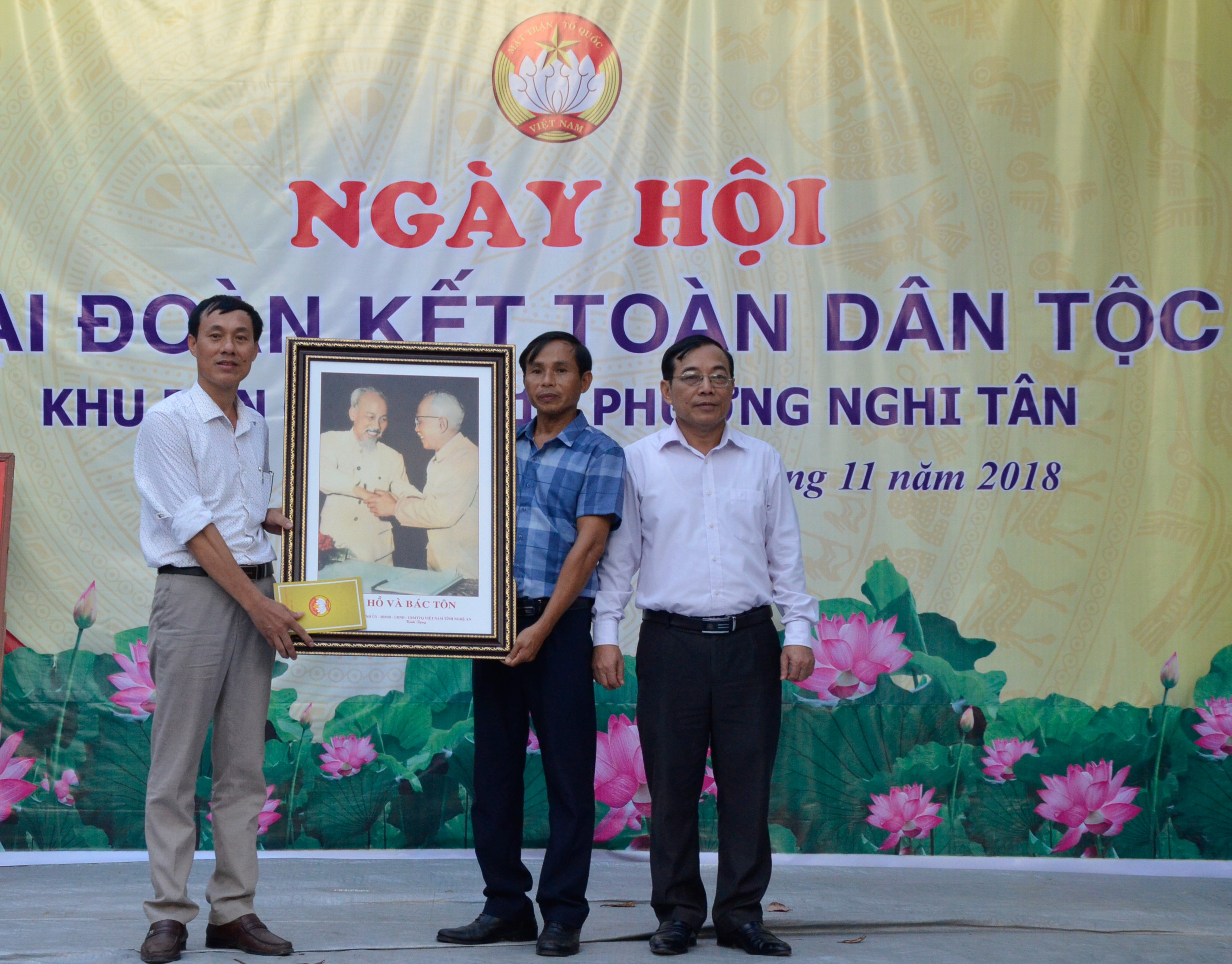 Chủ tịch Ủy ban MTTQ tỉnh Nguyễn Văn Huy trao tặng bức tranh Bác Hồ và Bác Tôn cho khối 1, phường Nghi Tân (Cửa Lò). Ảnh Thanh Lê