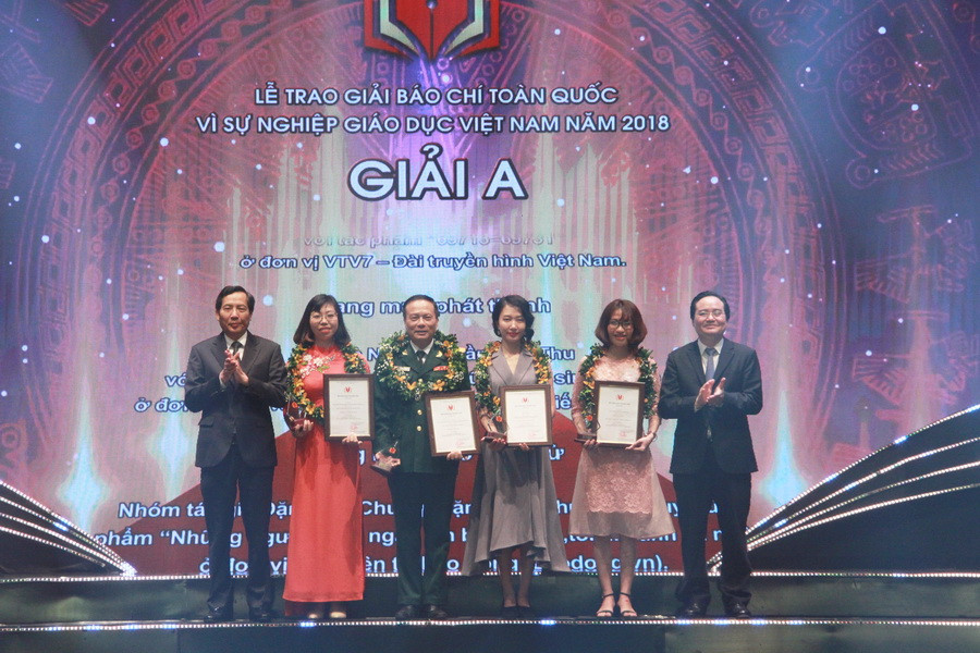 Bộ trưởng Phùng Xuân Nhạ và nhà báo Thuận Hữu trao giải cho các tác giả đạt giải nhất. Ảnh: PV