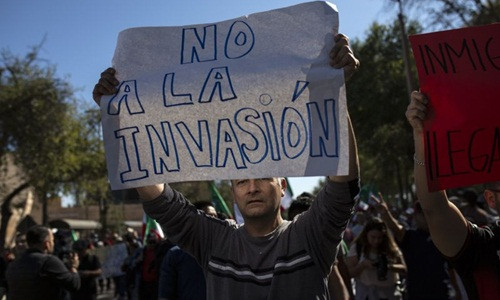Một người biểu tình phản đối đoàn di cư Trung Mỹ ở thành phố Tijuana, Mexico, ngày 18/11. Ảnh: AP.