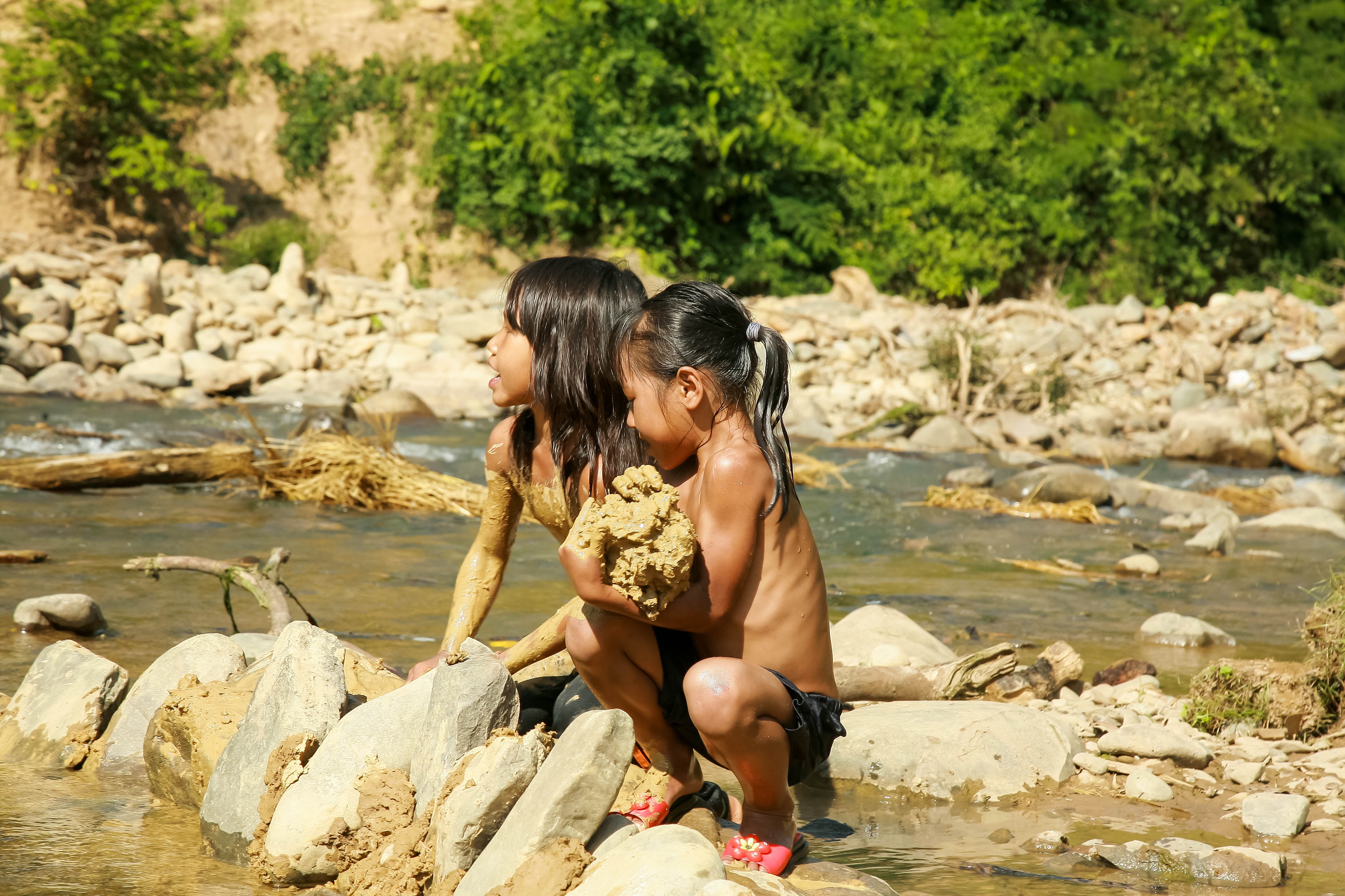 Những đứa lớn hơn đã biết ra suối bắt cá, vớt rong cải thiện bữa ăn. Ảnh: Tuấn Anh