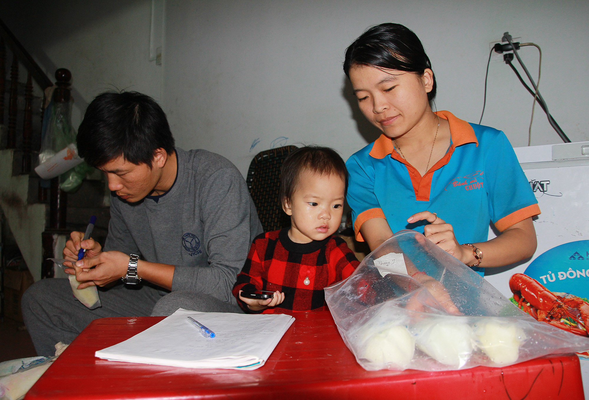 Gia đình chị Mạnh Thị Phước Ngọc đang đánh dấu, sắp xếp lại các túi đựng sữa mẹ được mọi người quyên tặng. Ảnh: Chu Thanh