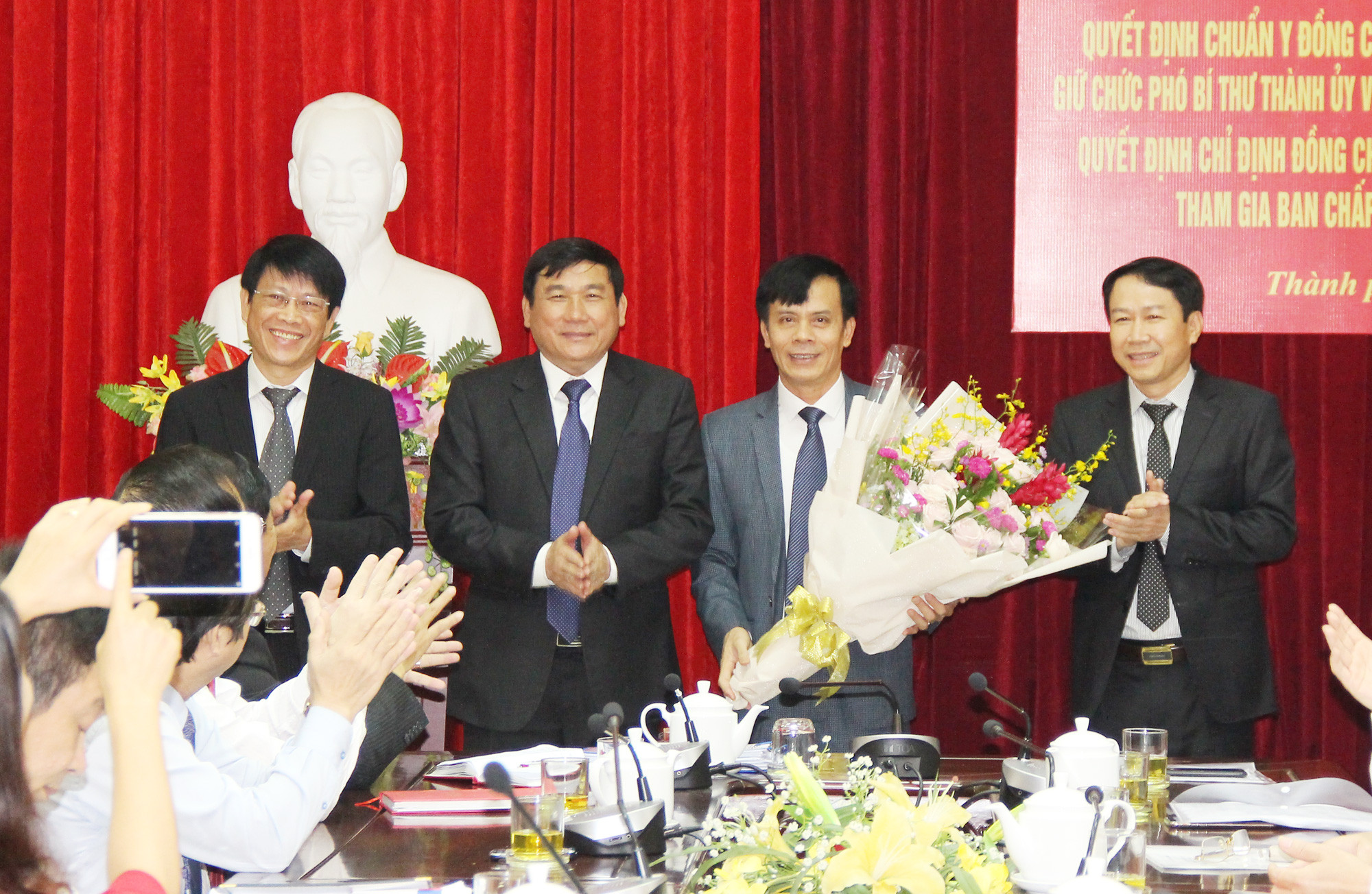 Các đồng chí lãnh đạo UBND thành phố tặng hoa chúc mừng đồng chí Trần Ngọc Tú. Ảnh: Mai Hoa