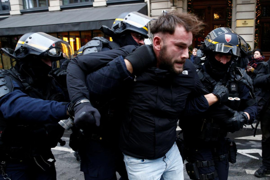 Cảnh sát chống bạo động CRS bắt giữ một người biểu tình ở một con phố gần ga xe lửa Saint Lazare. Ảnh: Reuters