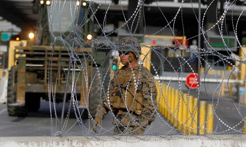 Lính Mỹ dựng hàng rào thép gai để ngăn đoàn người di cư tại biên giới Mexico. Ảnh: Reuters.