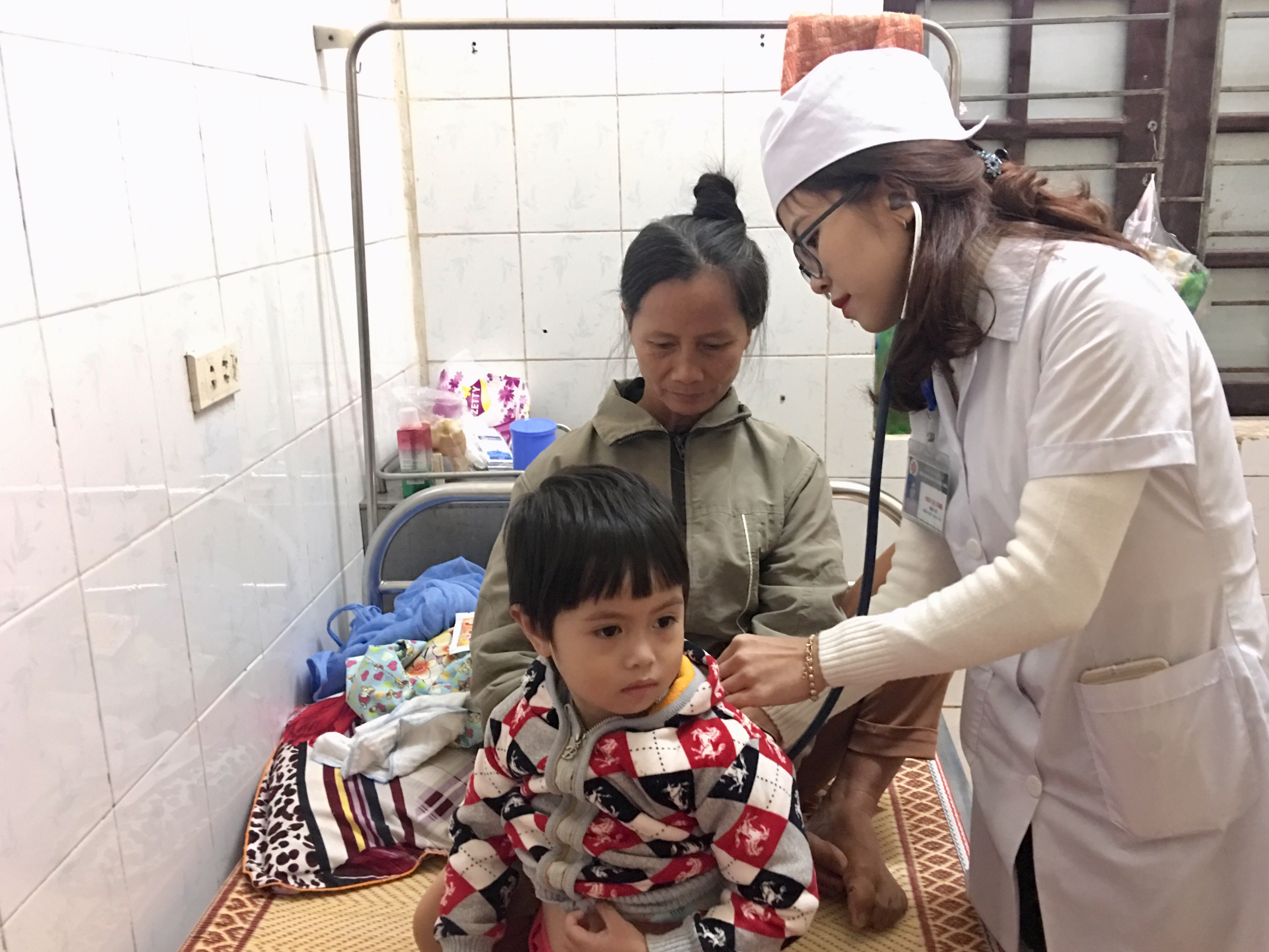 Bác sỹ Phan Thị Lương - Bệnh viện đa khoa Đô Lương đang khám bệnh cho trẻ bị viêm phổi do thời tiết lạnh. Ảnh: Ngọc Phương
